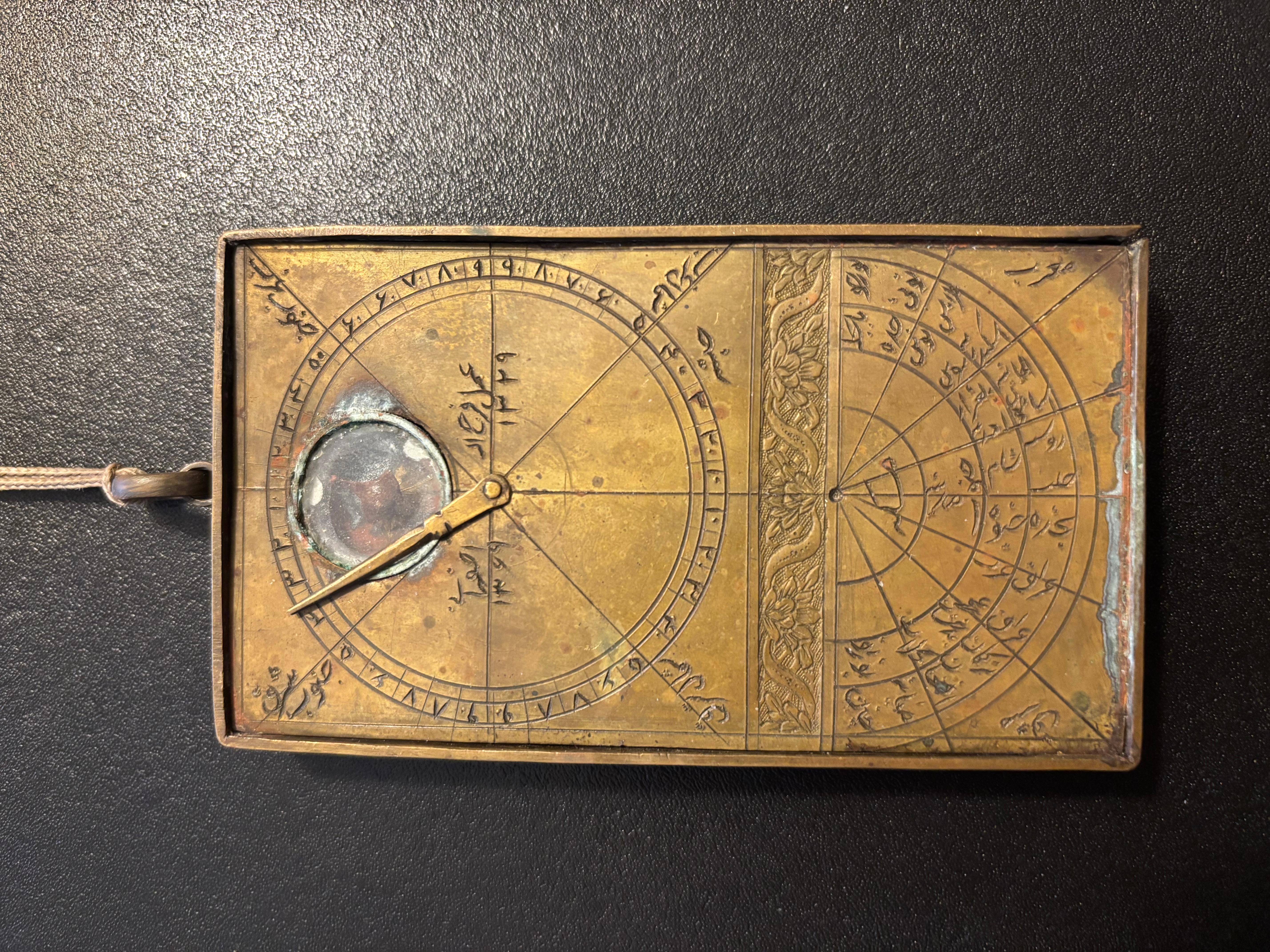 Boussole Qibla indienne en laiton gravé du 19e siècle. 

La boussole avec aiguille en laiton et couvercle en verre, le revers gravé avec des tableaux. 

4,2 pouces de haut 2,3 pouces de large 

Une boussole de qibla (parfois aussi appelée indicateur
