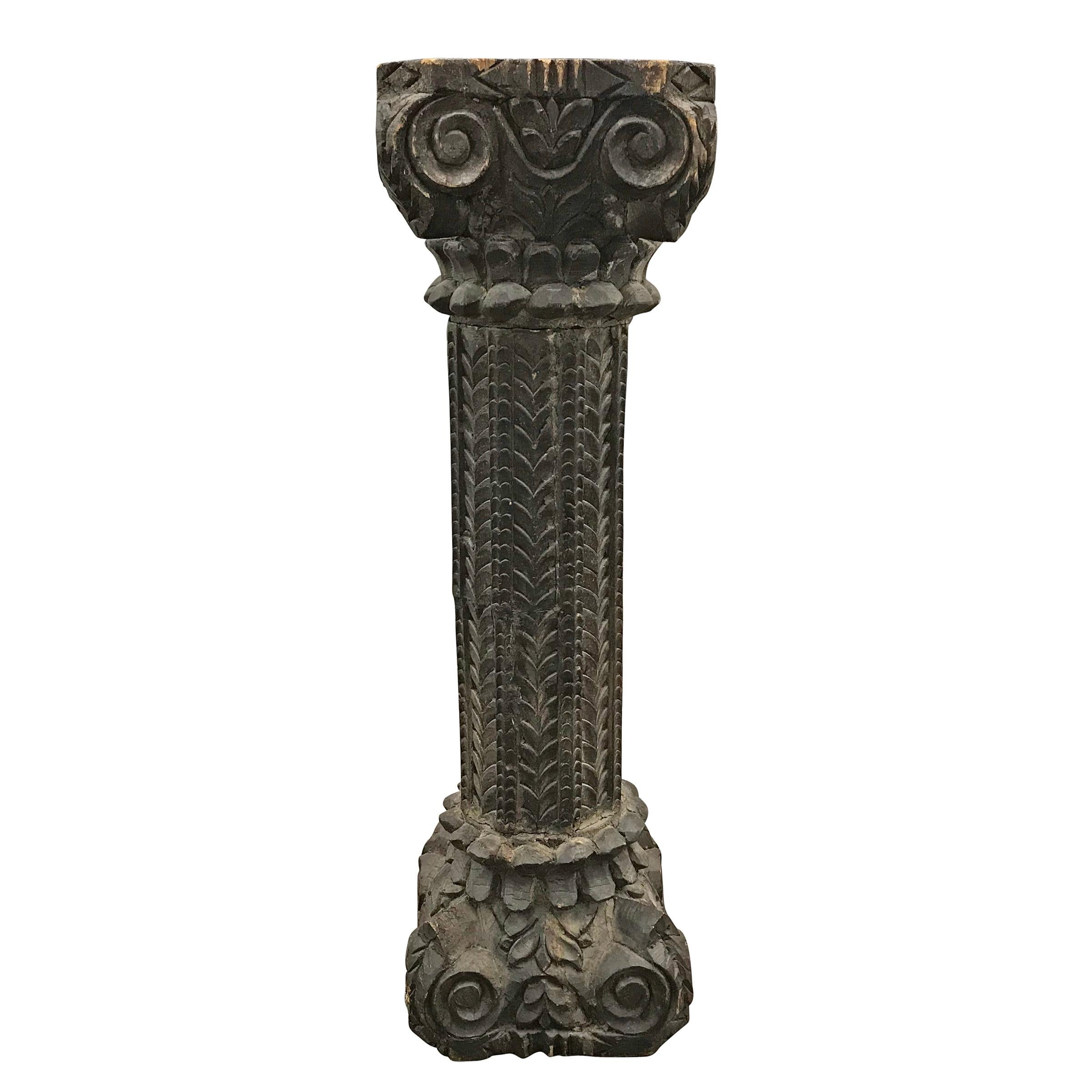 A 19th century Indian wood stylized ionic column with carved floral capital and base, and a wonderfully stylized central column. This probably adorned a large home, where multiple columns, figures and floral carved panels would have provided an