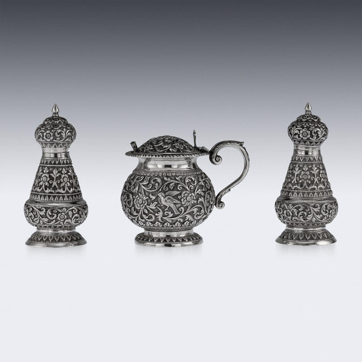 Antique late 19th century Indian solid silver repousse three-piece condiment set, comprising of a lidded mustard pot with spoon, salt and pepper shakers, each piece is profusely and beautifully repousse' decorated with scrolling foliage and flowers