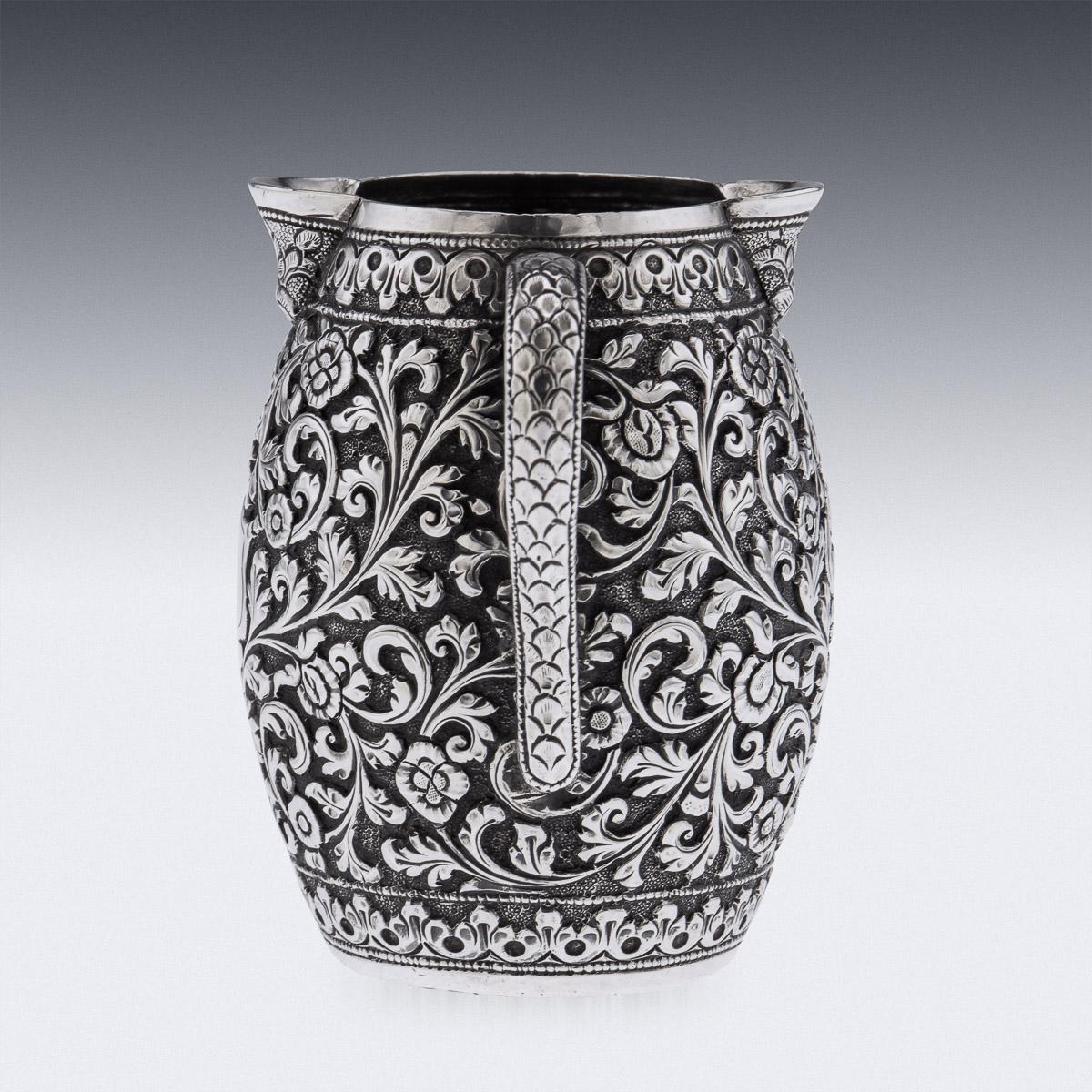 Antique late-19th Century Indian Kutch (Cutch), Bhuj, (Gujarat region) very unusual hand-crafted solid silver cream jug, finely chased throughout with scrolling leaves and floral patterns on a finely tooled matted ground. The center with a vacant