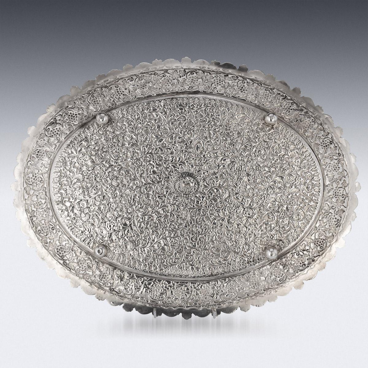 19th Century Indian Kutch (Cutch), Bhuj, (Gujarat region) hand-crafted solid silver tray, of shaped oval form, finely chased throughout with scrolling grapevines and floral patterns on a finely tooled matted ground, the tray resting on four ball