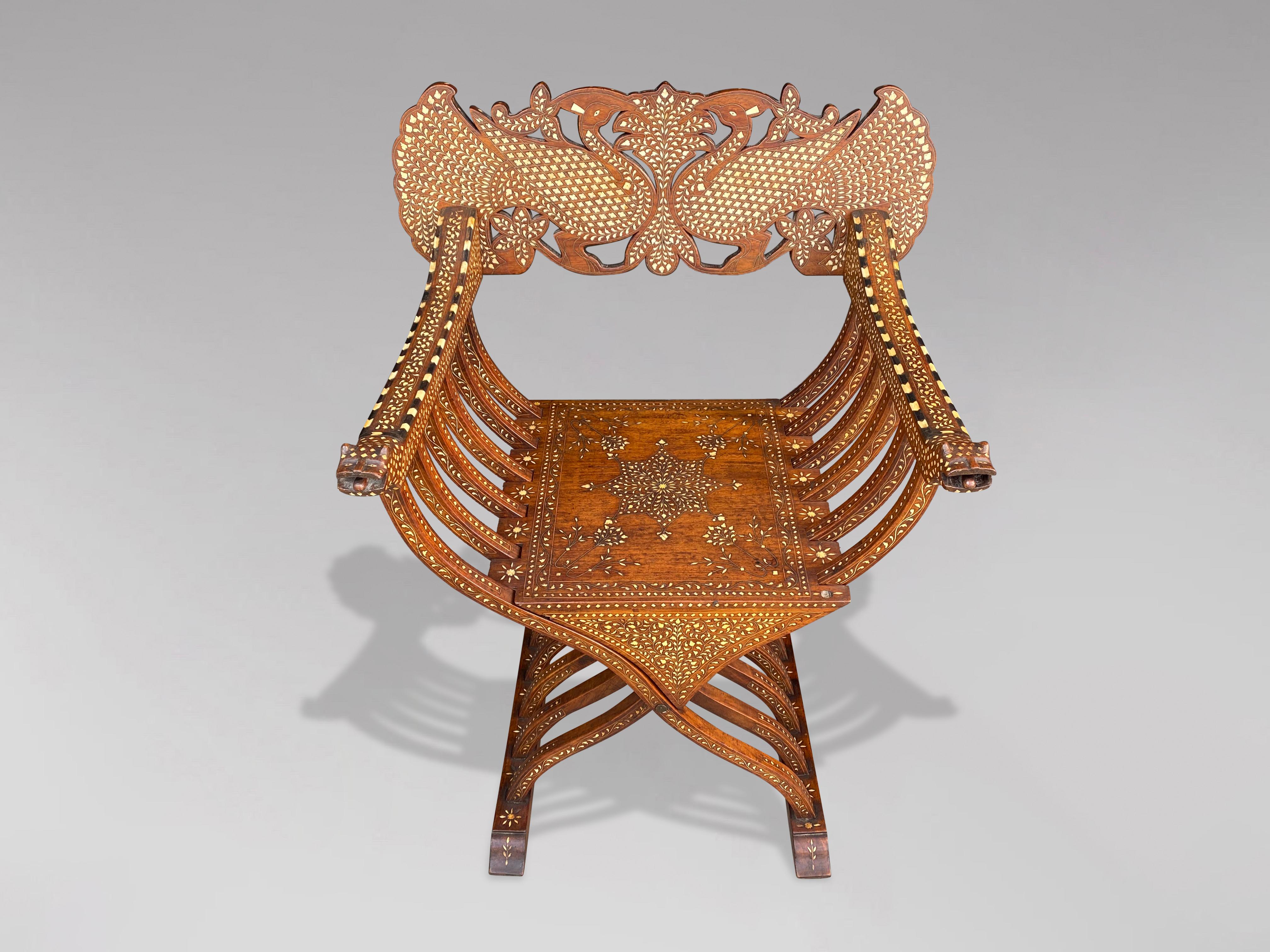 A very decorative and elaborate inlaid late 19th century folding scissors Savonarola armchair. With a carved foliate and twin peacock back rail, leopard head arms and inlaid with bone, mother of pearl, ebony and mixed woods. Great detail and good