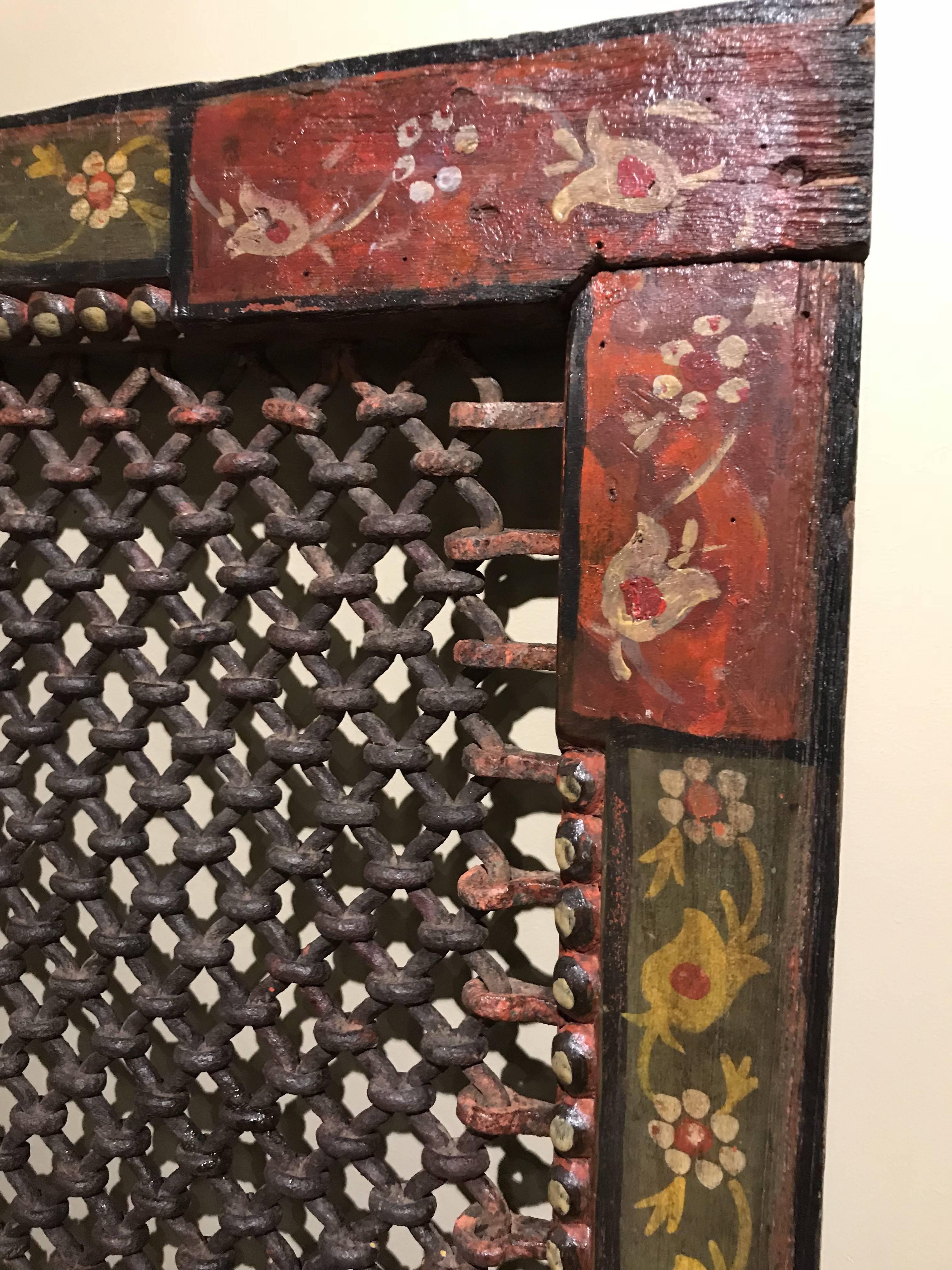 A fine example of a Indian polychrome surround with woven wrought iron grill and wooden border, painted with foliate decoration, probably dating to the 19th century. Perhaps originally used as a shutter or window on an Indian temple or home. Very