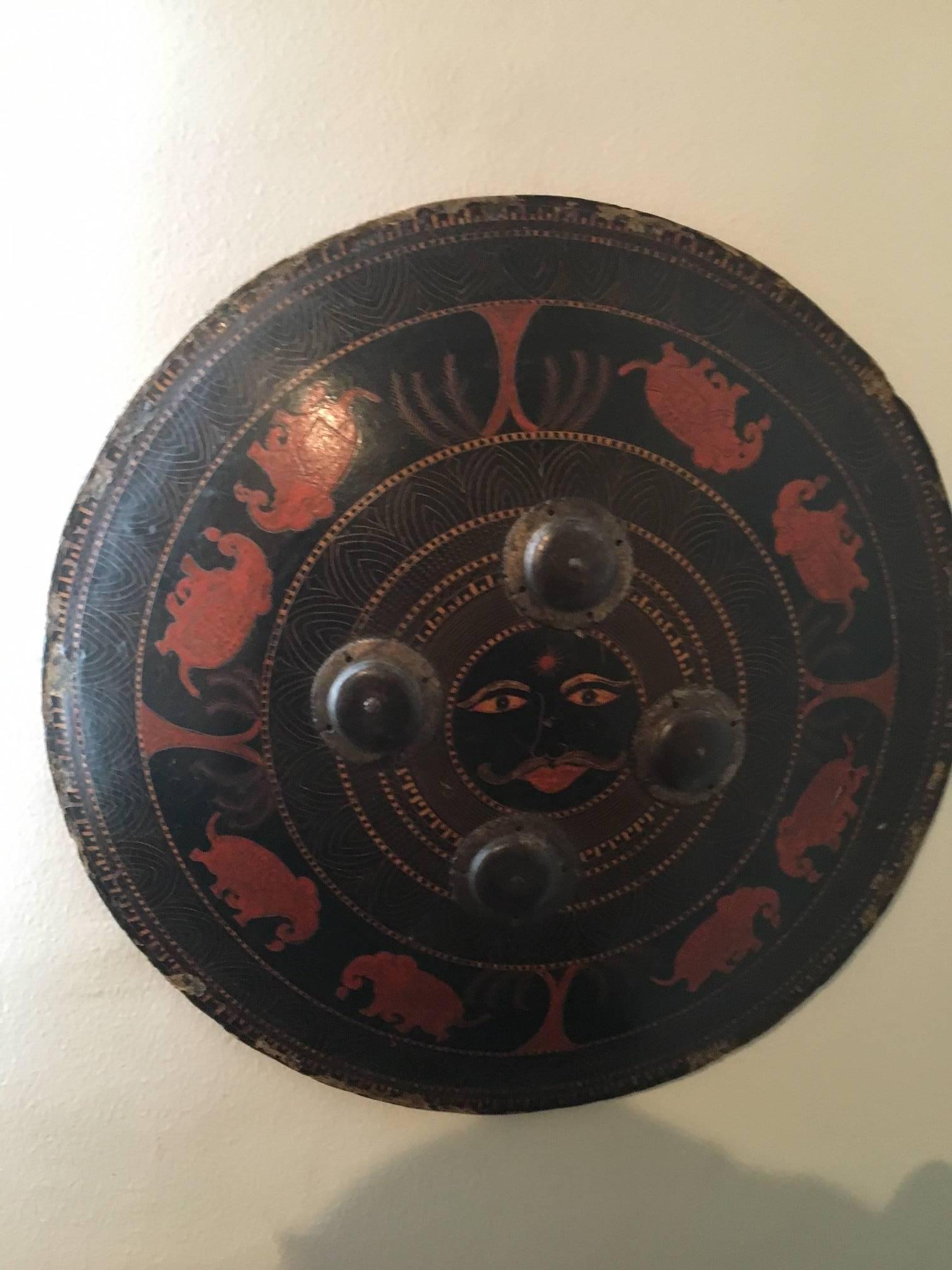 19th century Indian shield representing some elephants and a face in the middle.
