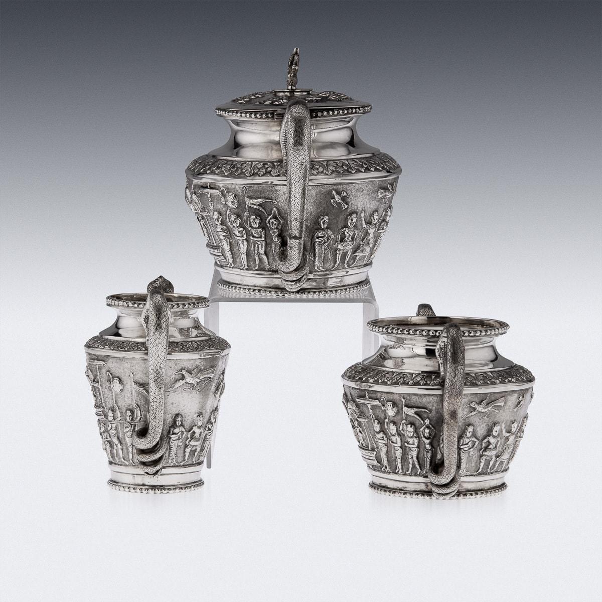 Antique 19th Century Indian Colonial solid silver three-piece tea set, comprising of teapot, sugar bowl, & cream jug, each straight tapered body is profusely and beautifully repousse' decorated with a religious processions with men carrying idols, a