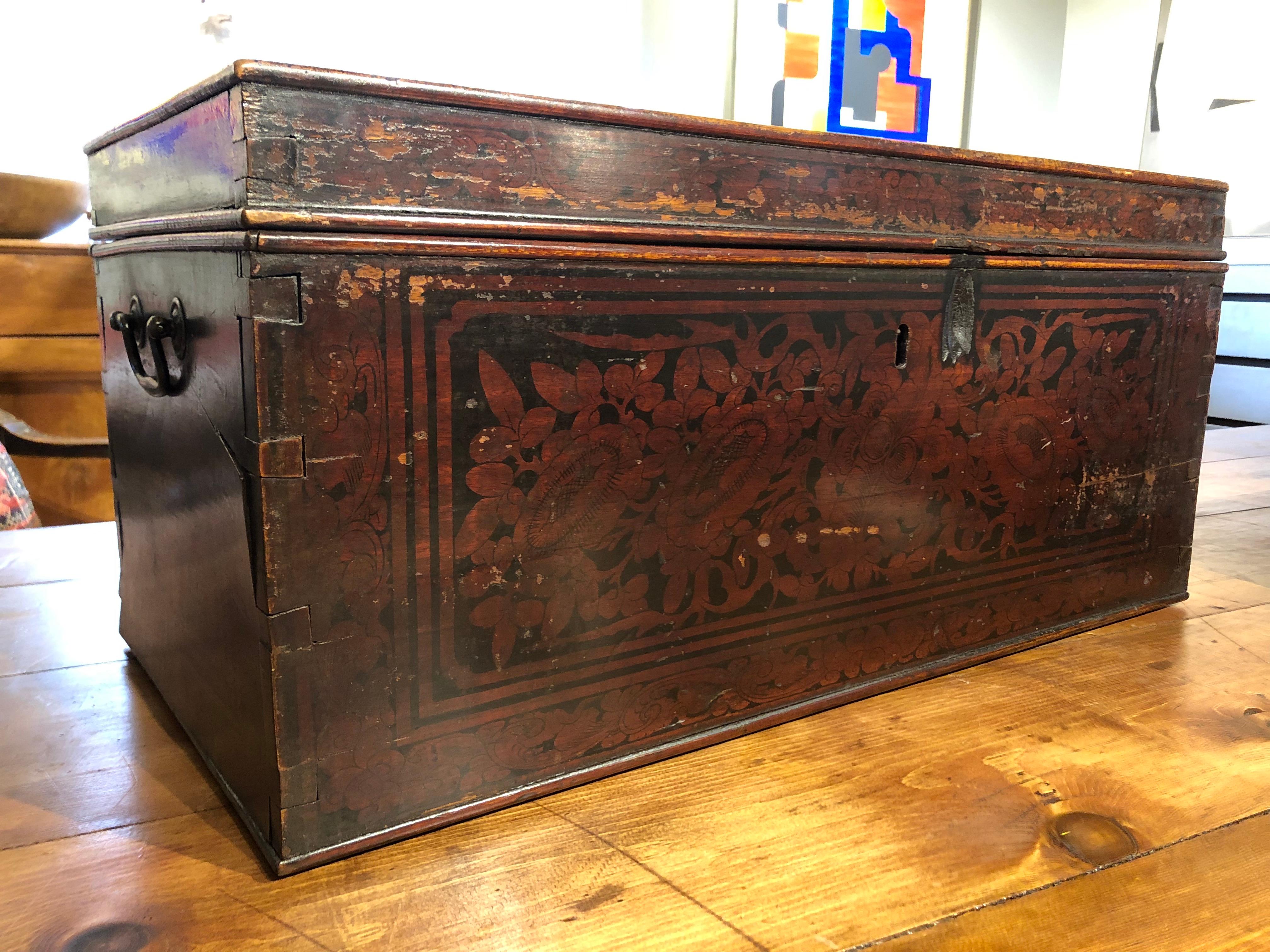 Made of richly patinated teak with intricate red and black lacquer floral decoration, this 19th century red and black lacquered Indonesian document box has dove tailed construction retaining the original brass carrying handles. A totally unique way