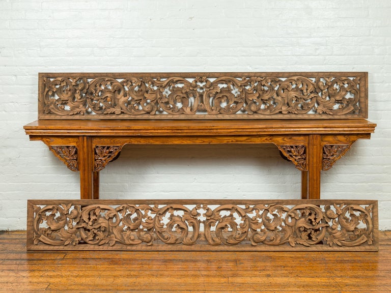 An antique 19th century Indonesian carved wooden panel from a temple entrance, with scrolling foliage. Only one of the panels in the photo is now available. Crafted in the 19th century, this temple panel captures our attention with its delicate