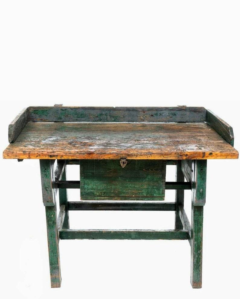 A most unique antique industrial work table with outstanding patina. Born in the 19th century, having richly worn, warm, rustic, aged pine wooden top with partial raised gallery backsplash, over a single-drawer to front, the drawer front embellished