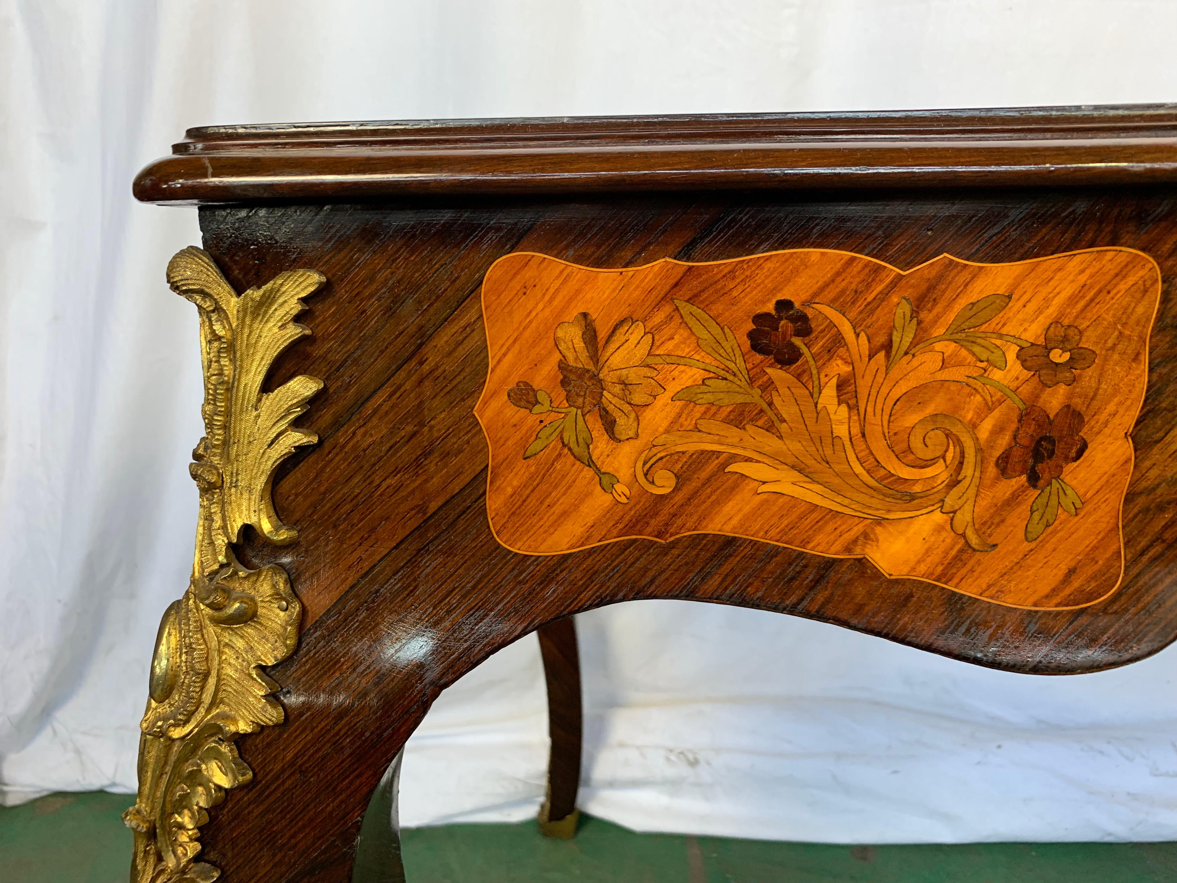 A fine 19th century French Pollard walnut marquetry and ormolu centre table. The ornate top inlaid in fruitwood with musical trophies. Supported on cabriole legs.