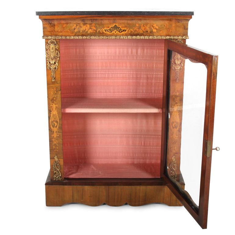 A pretty burl walnut side cabinet with inlaid marquetry details and finely-finished gilt bronze mounts, the single glass door opening to a shelved interior, and with a grey marble top, Circa 1870

Measures: 31.5 wide x 12 deep x 43.5 tall.