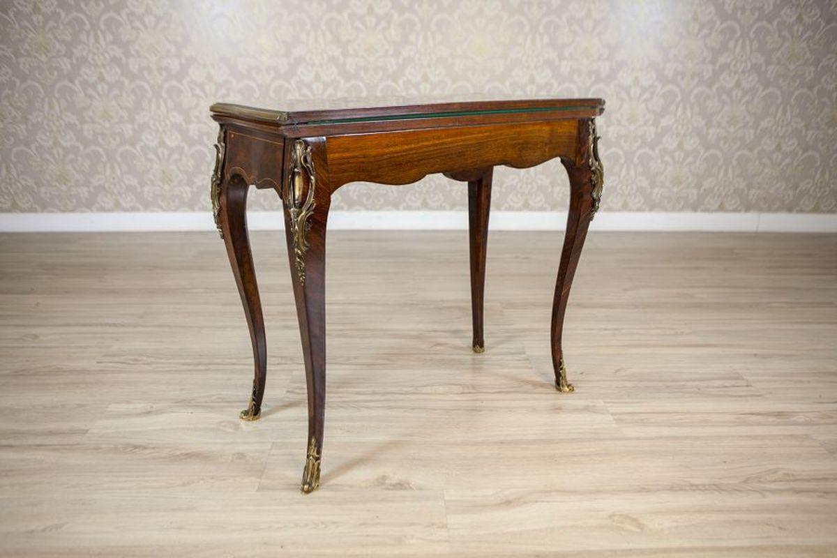 19th-Century Inlaid Card Table Lined With Green Fabric

A wall-mounted console-style piece with a double-sided, foldable top supported by curved legs. The tabletop consists of two sections connected by hinges, allowing it to rotate around an