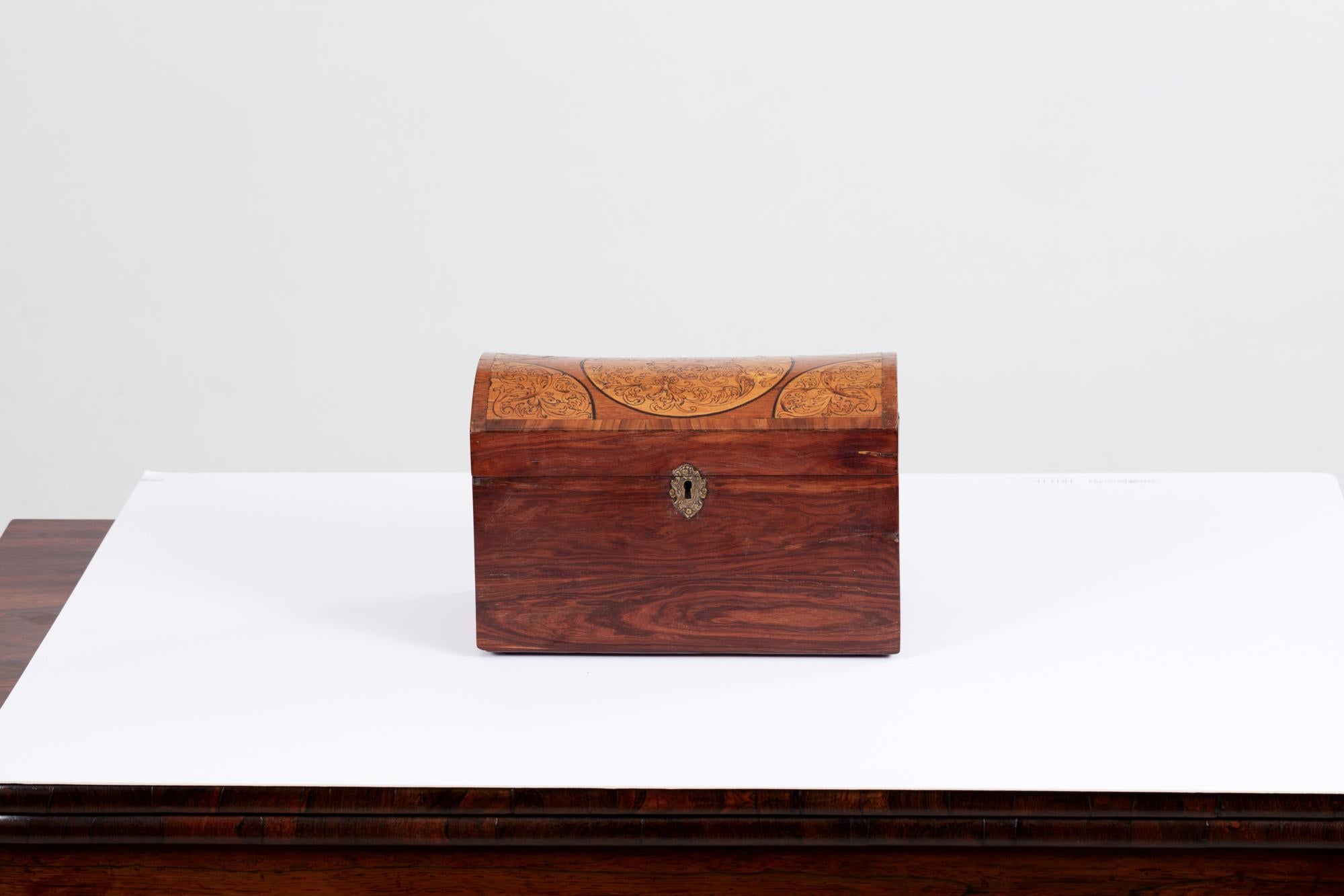 19th Century inlaid dome-top wooden box with acanthus leaf detail, decorative brass lock and secret drawer.