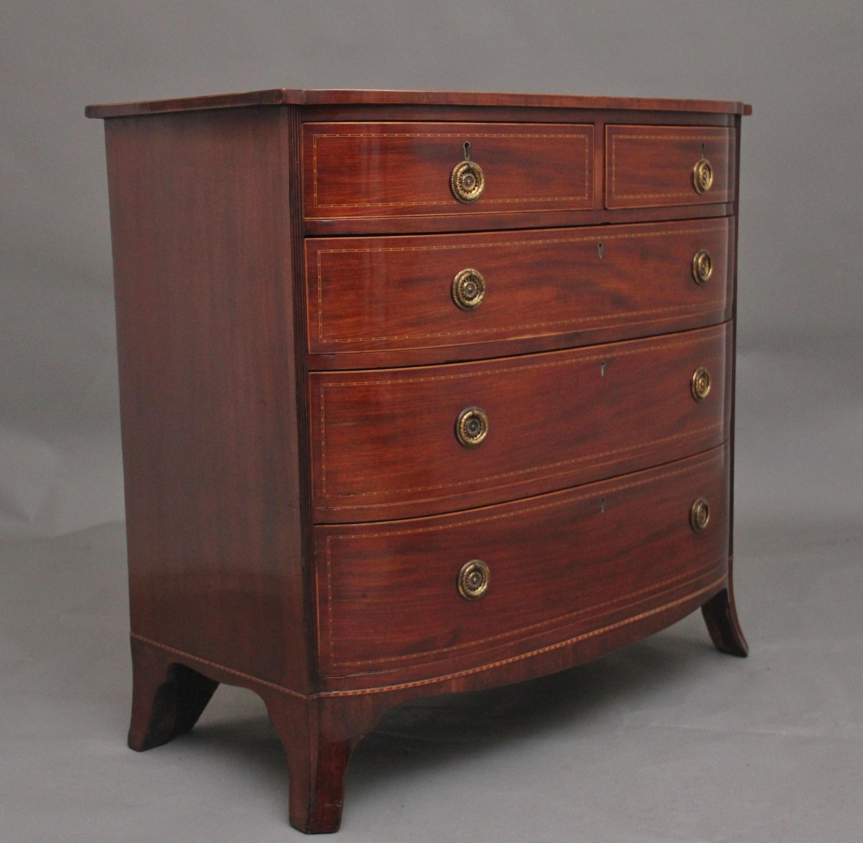 19th Century mahogany bowfront chest of drawers, having a nice figured shaped top with decorative inlay along the edge, two short over three long oak lined drawers with brass ring handles, further decorative inlay on the drawer fronts, supported on
