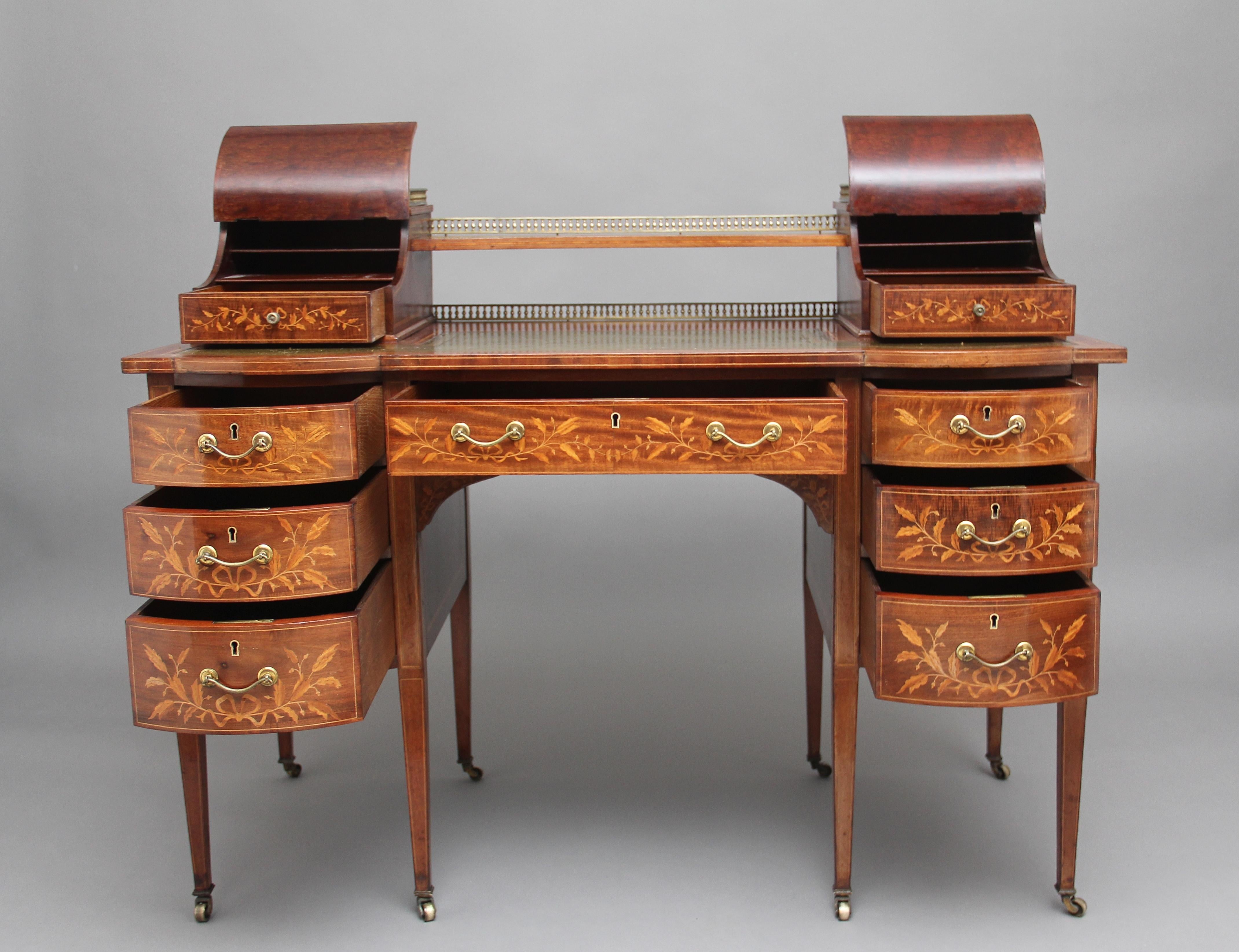 19th century inlaid mahogany desk, the top having a shelf flanked either side by concave hinged stationary compartments beautifully inlaid with scrolling flowers and urns, each with a drawer with fitted compartments, the shelf and the compartments