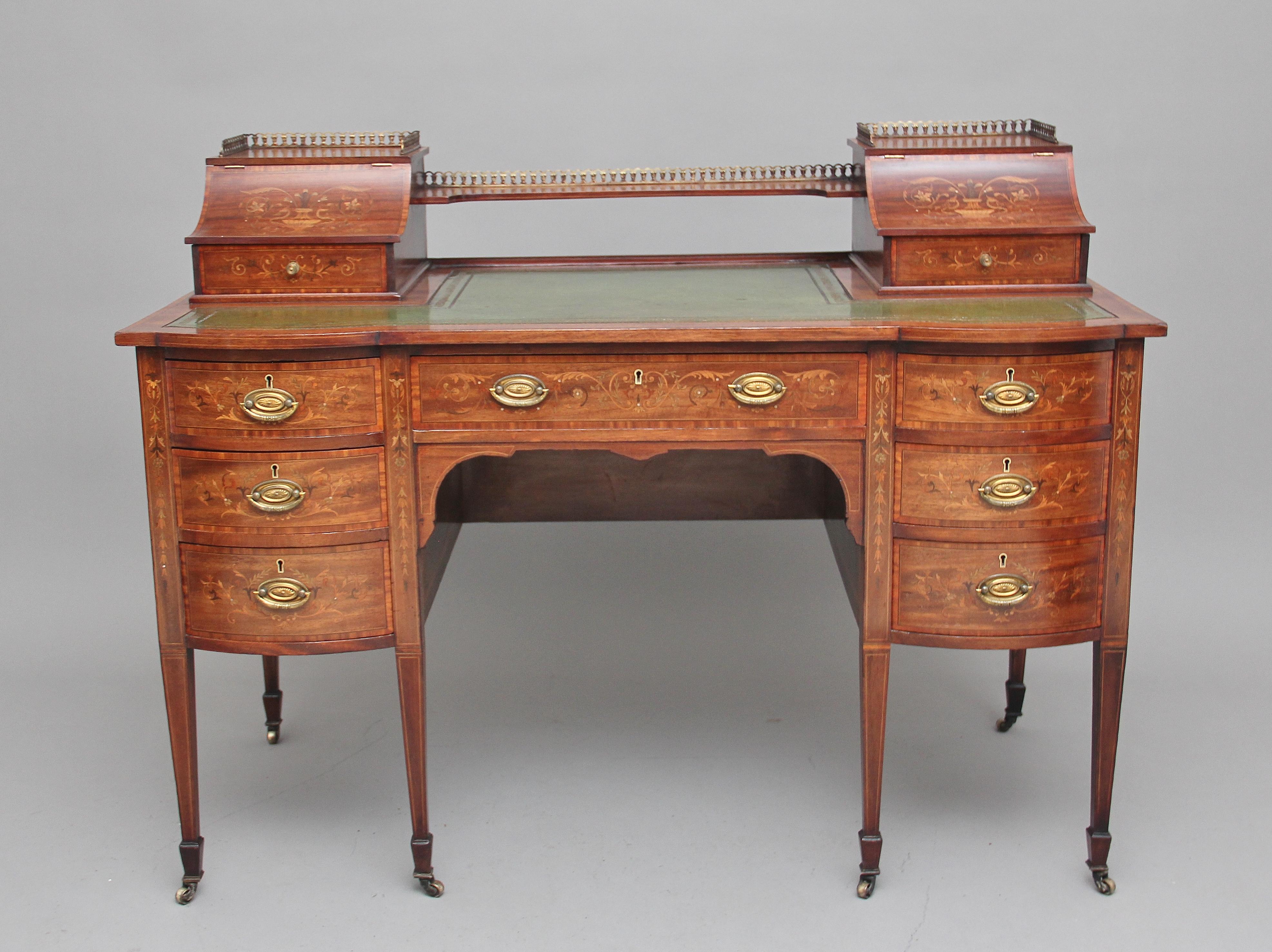 19th century inlaid mahogany desk with satinwood crossbanding, the top having a shelf flanked either side by concave hinged stationary compartments beautifully inlaid with scrolling flowers and urns, each with a drawer with fitted compartments, the