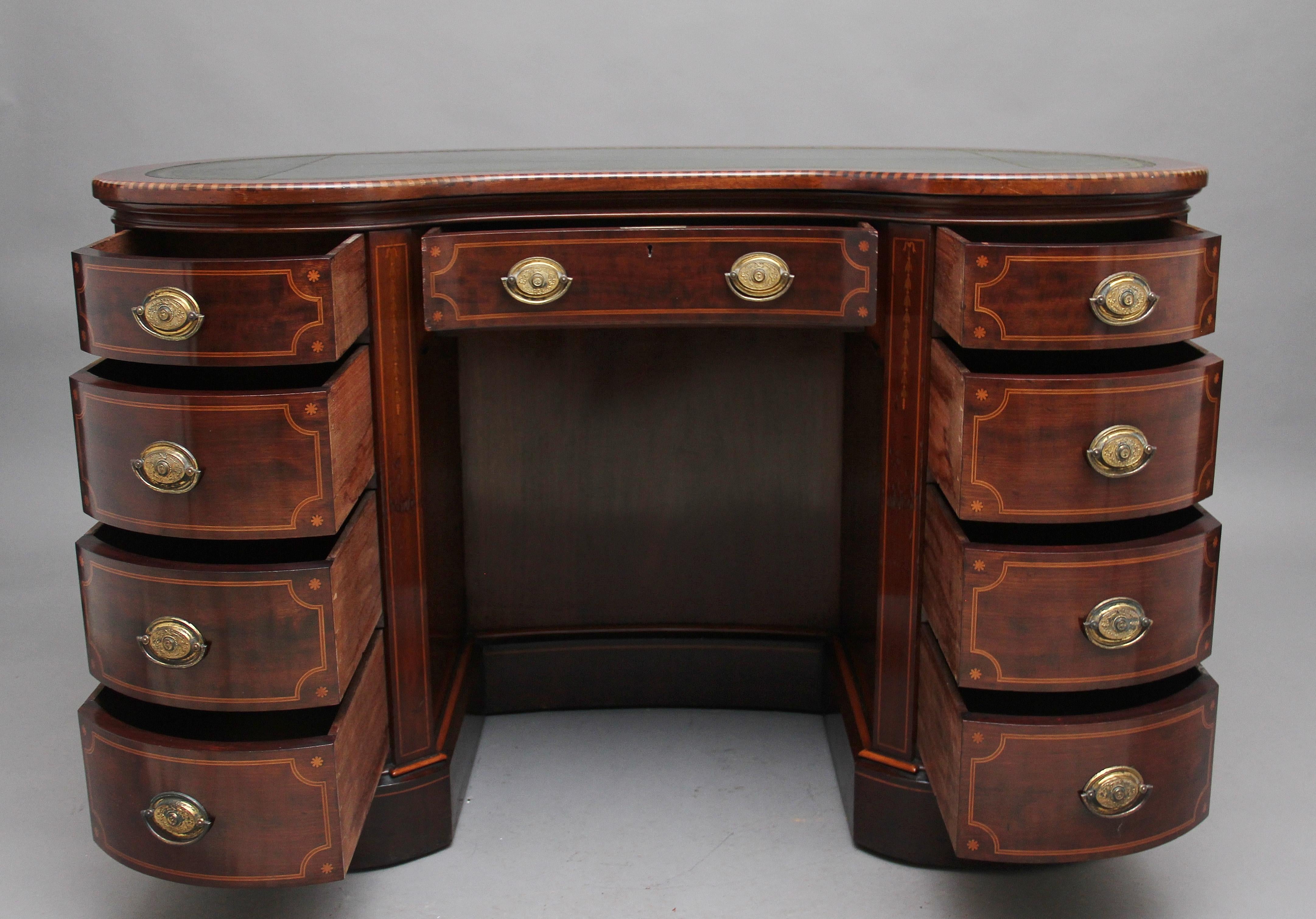 A superb quality 19th century freestanding inlaid mahogany kidney shaped desk, the top having the original green leather writing surface decorated with blind and gold tooling, the edge of the top having boxwood and chequered inlay, a selection of