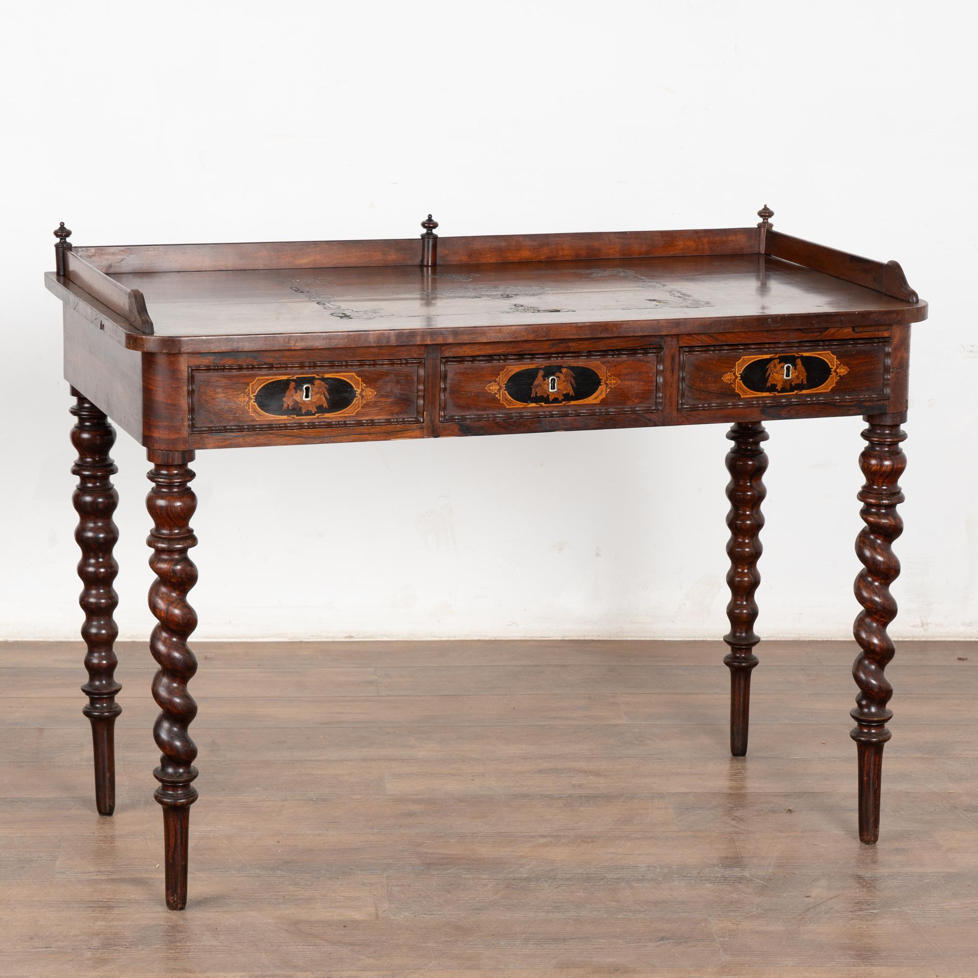Distinctive and elegant, this small ladies writing desk has decorative inlaid brass filigree embellished with colorful stone and shell details along the top. 
Please enlarge photos to appreciate the attractive rich mahogany grain in the top and