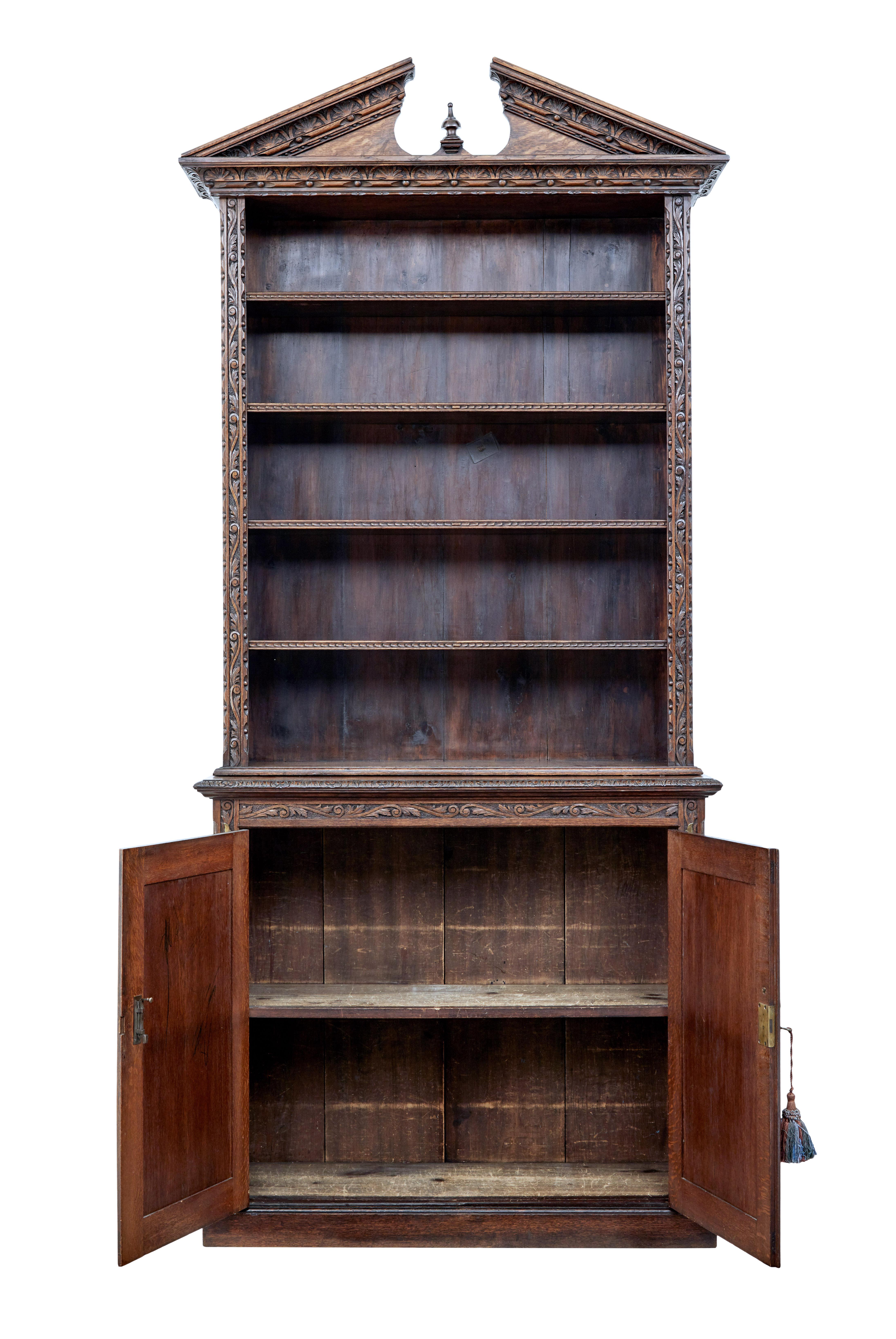 19th century inlaid oak architectural cabinet bookcase circa 1880.

Unusual open bookcase on cabinet base. Top decorated with architectural pediment, further carved edge which is echoed on the edges of the 4 adjustable shelves.

Double door