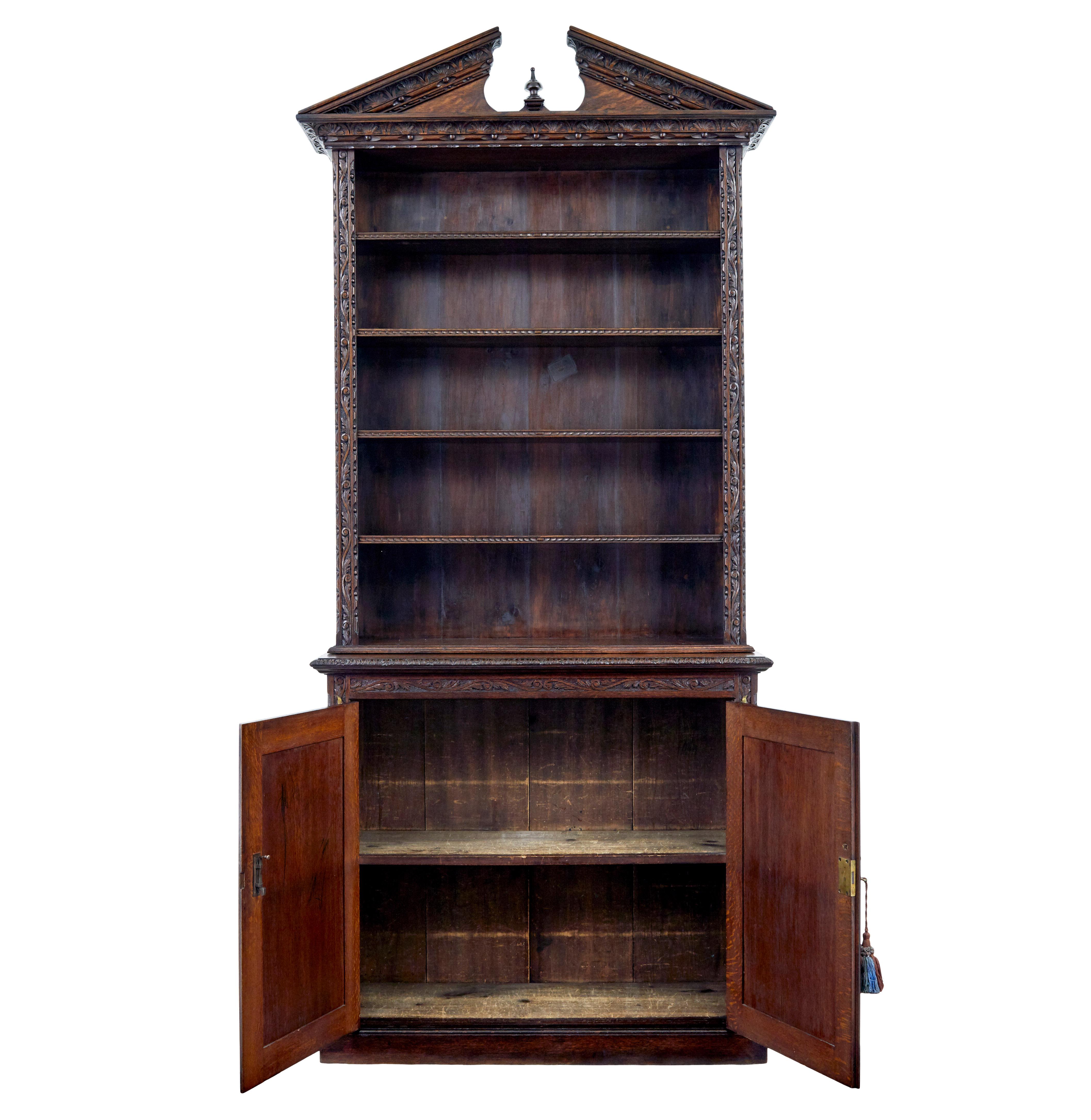 19th century inlaid oak architectural cabinet bookcase circa 1880.

Unusual open bookcase on cabinet base.  Top decorated with architectural pediment, further carved edge which is echoed on the edges of the 4 adjustable shelves.

Double door