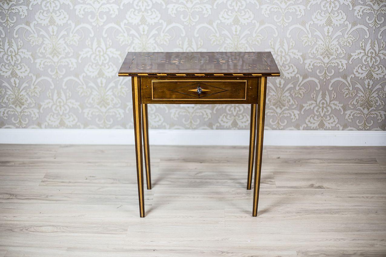 We present you a narrow, rectangular side table in the console type.
It is from the late 19th century.
This piece of furniture is supported on straight legs. There is also a drawer under the top.
The legs and edges of the top are decorated with
