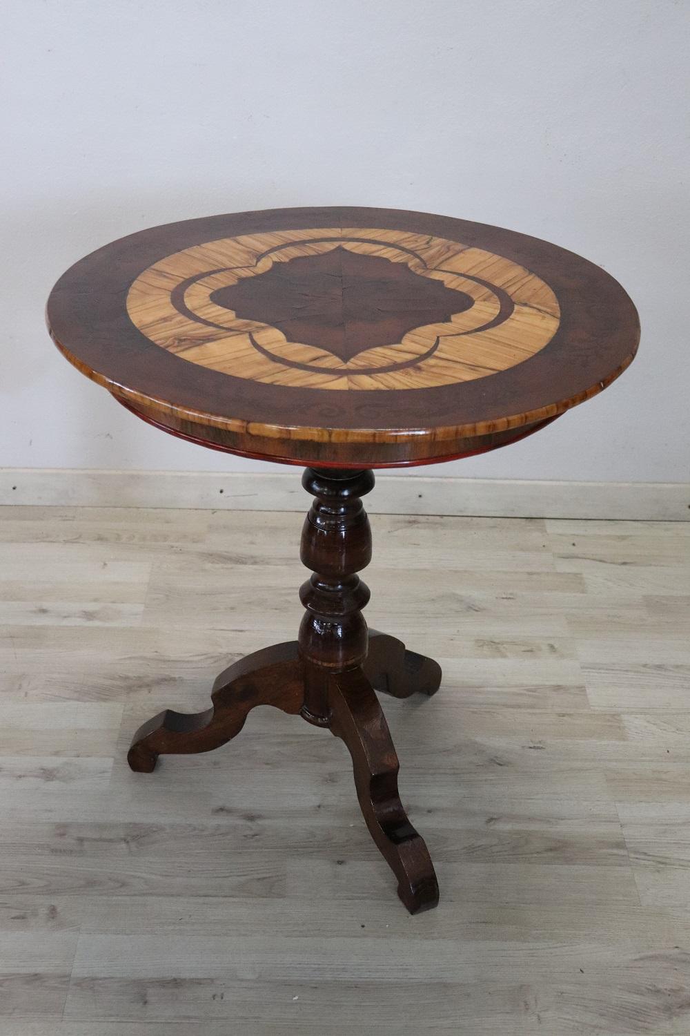 Rare and fine quality Italian round gueridon table or pedestal table. The top features refined inlay work with precious olive wood. The central stem is finely turned. Really delicious table.