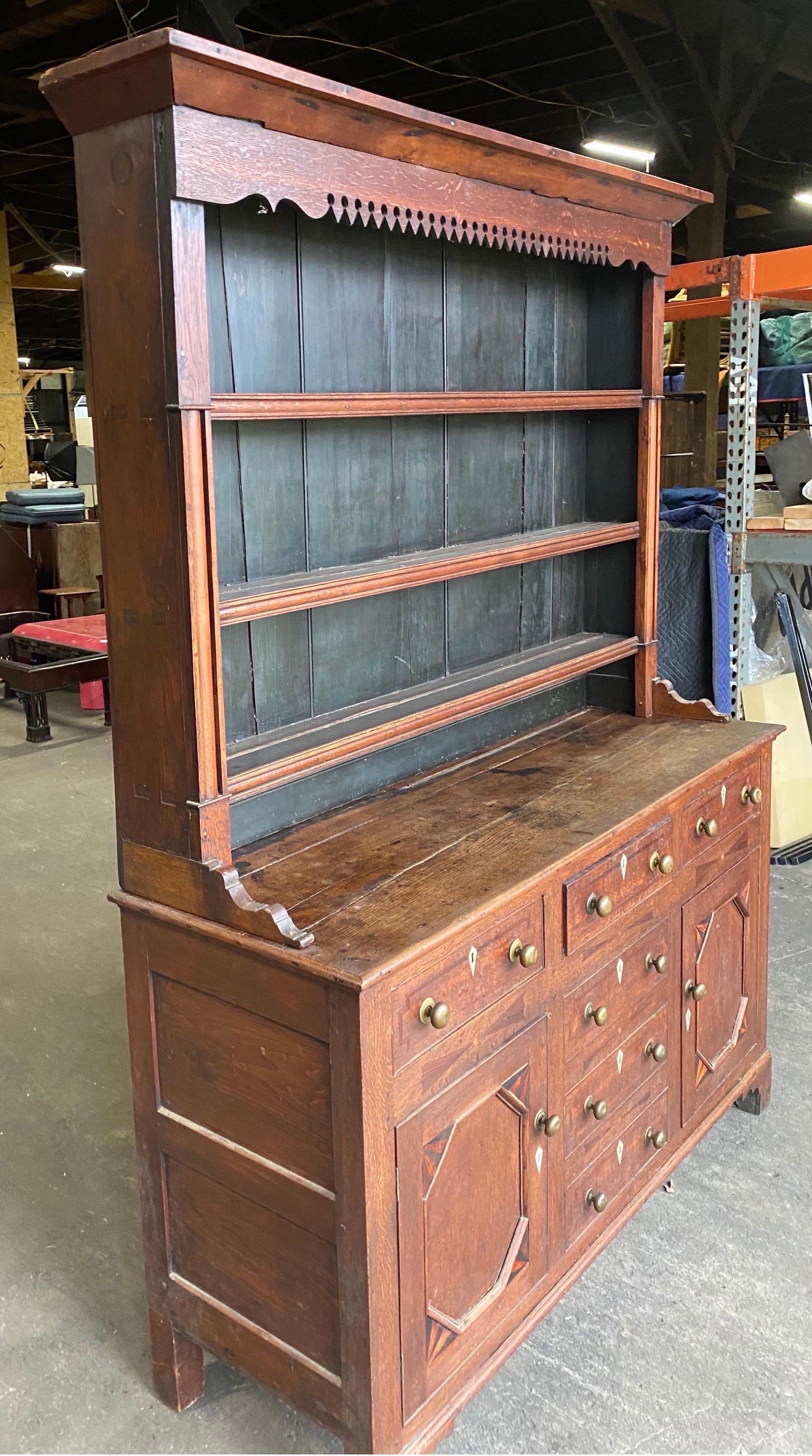 19th century inlaid Welsh oak cupboard. 2 part oak cupboard with inlaid quarter fans and escutcheons. Base has three drawers over two doors and three faux drawers.