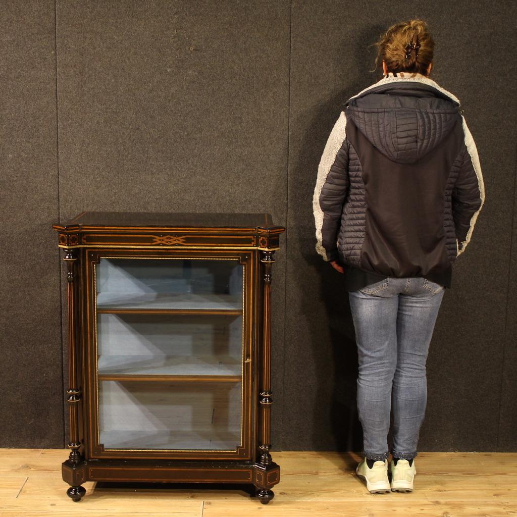 Englischer Vitrinenschrank aus der zweiten Hälfte des 19. Jahrhunderts. Ein eintüriger Schrank im viktorianischen Stil aus der Zeit Napoleons III. Die Vitrine ist mit hochwertigen Intarsien aus Ebenholz, Ahorn, Palisander und Mahagoni ausgestattet.