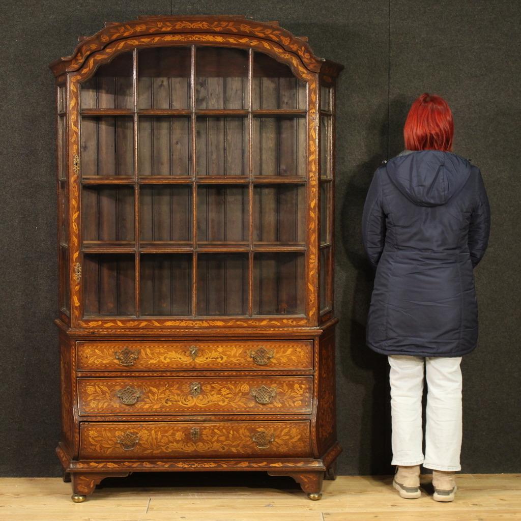 Vitrine hollandaise de la seconde moitié du 19e siècle. Sculpté et incrusté de décorations florales, en chêne, érable et bois fruitier, ce beau meuble présente un design agréable et un mobilier attrayant. La vitrine à double corps comporte trois