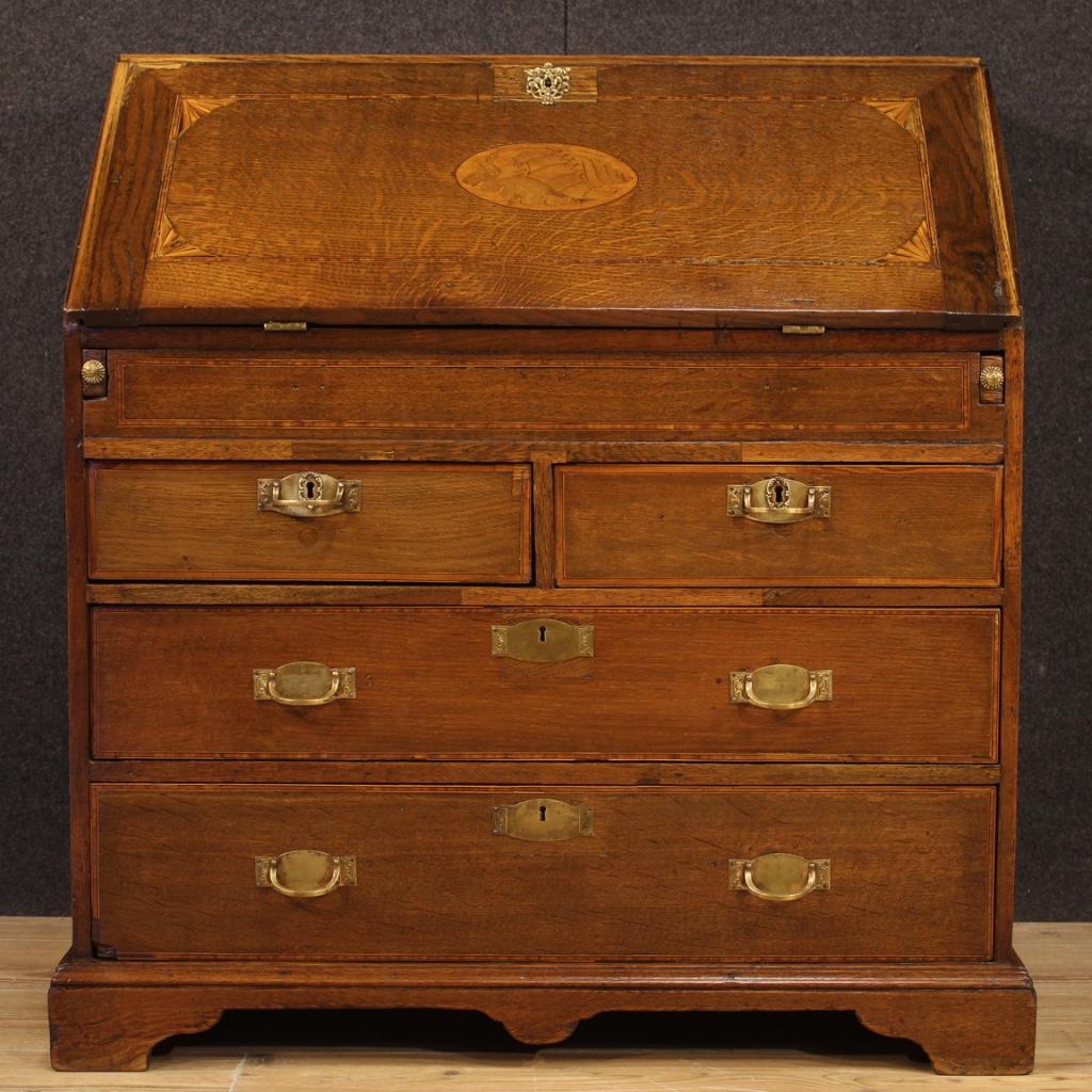 English bureau from the late 19th century. Beautiful furniture carved and inlaid in oak, maple, ebonized wood and fruitwood. Bureau with two smaller parallel drawers and two large drawers at the bottom. Fall-front adorned with a central shell