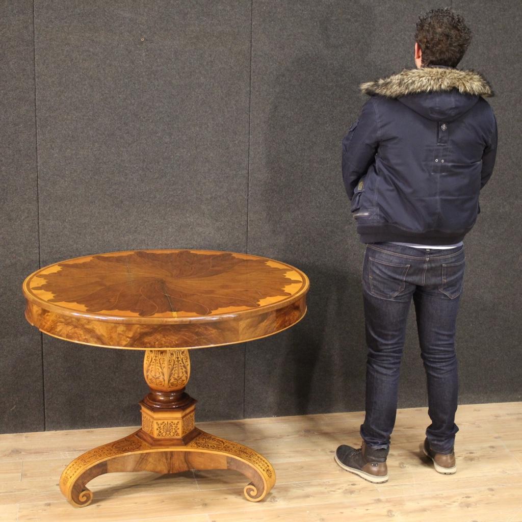 Antique Italian table from the first half of the 19th century. Furniture of exceptional quality inlaid and made of precious woods, rosewood, maple, amaranth, cherry and mahogany. Richly inlaid central stem table with three curled feet (see picture).