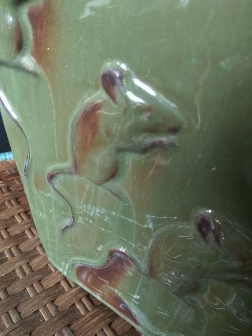 This vase of green color presents on each of its faces mice in bas-relief. It is particularly representative of 19th century artistic research. Indeed, artists draw from the forms of nature and look to the past and exotic countries. This trend is