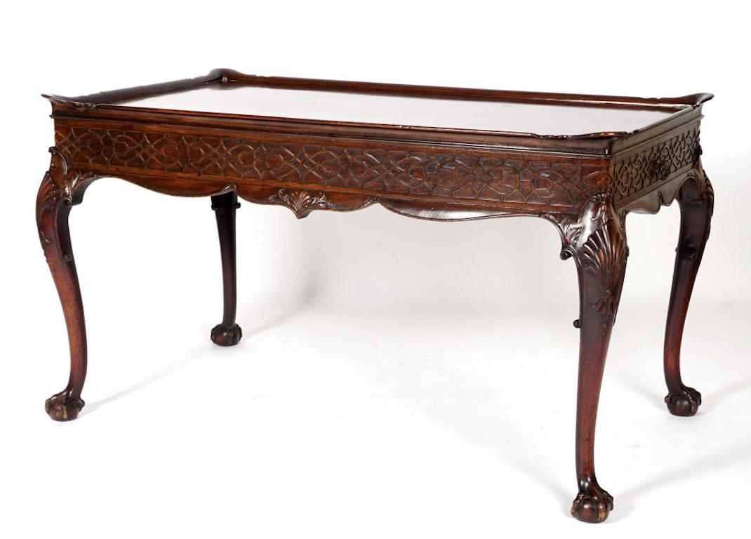 Exquisite 19th century Irish tea table. Carved mahogany in the Chinese Chippendale style. End drawers. One board top. Ball and claw cabriole legs. Shaped apron with Chippendale lattice work.
