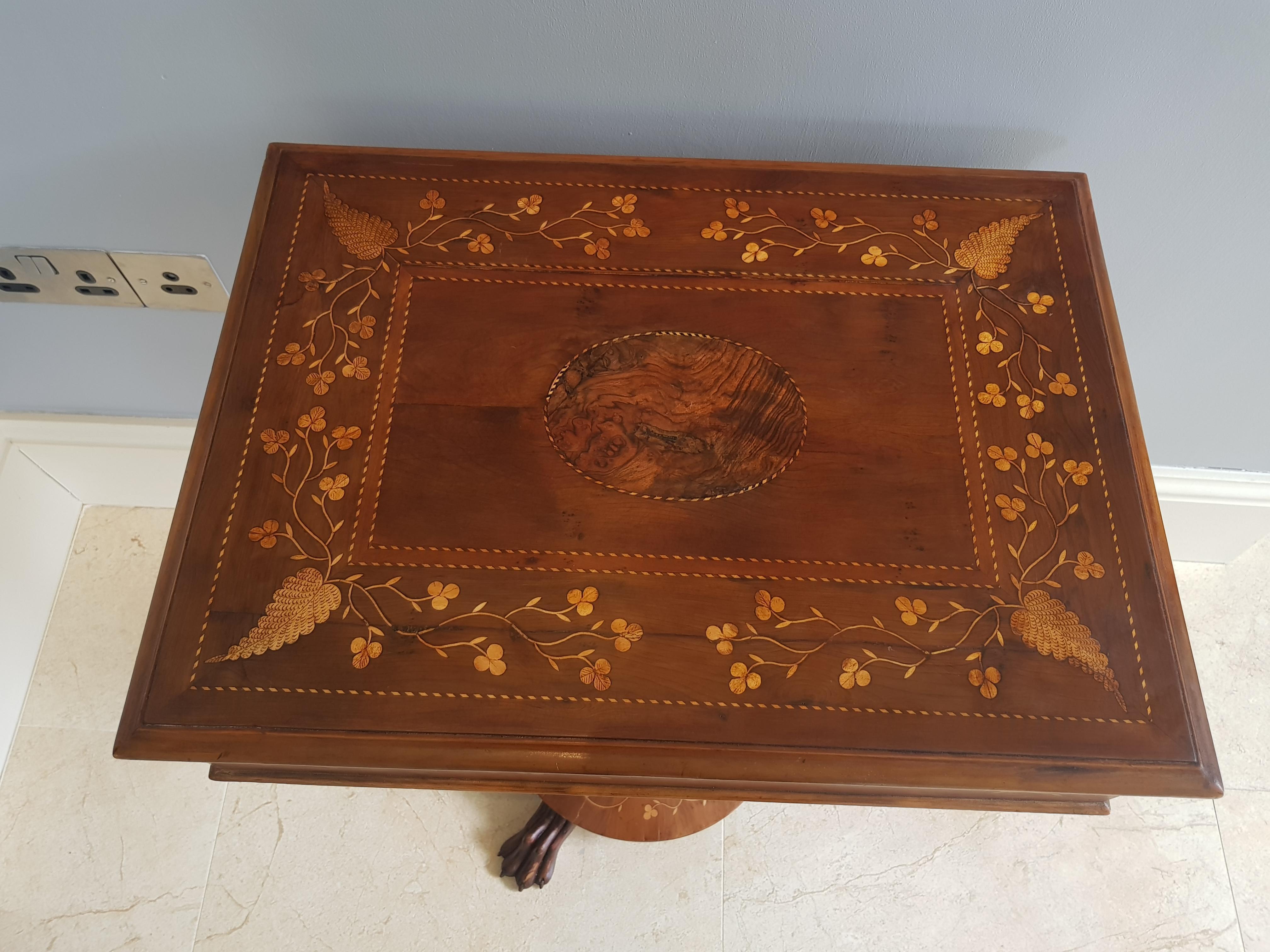 A fine example of mid-19th century Irish Killarney Marquetry Furniture.

The rectangular top ornately inlaid with shamrock and fern leaves. The lid lifts to reveal a fitted and sectioned sewing tray which lifts out to an underlying storage area.