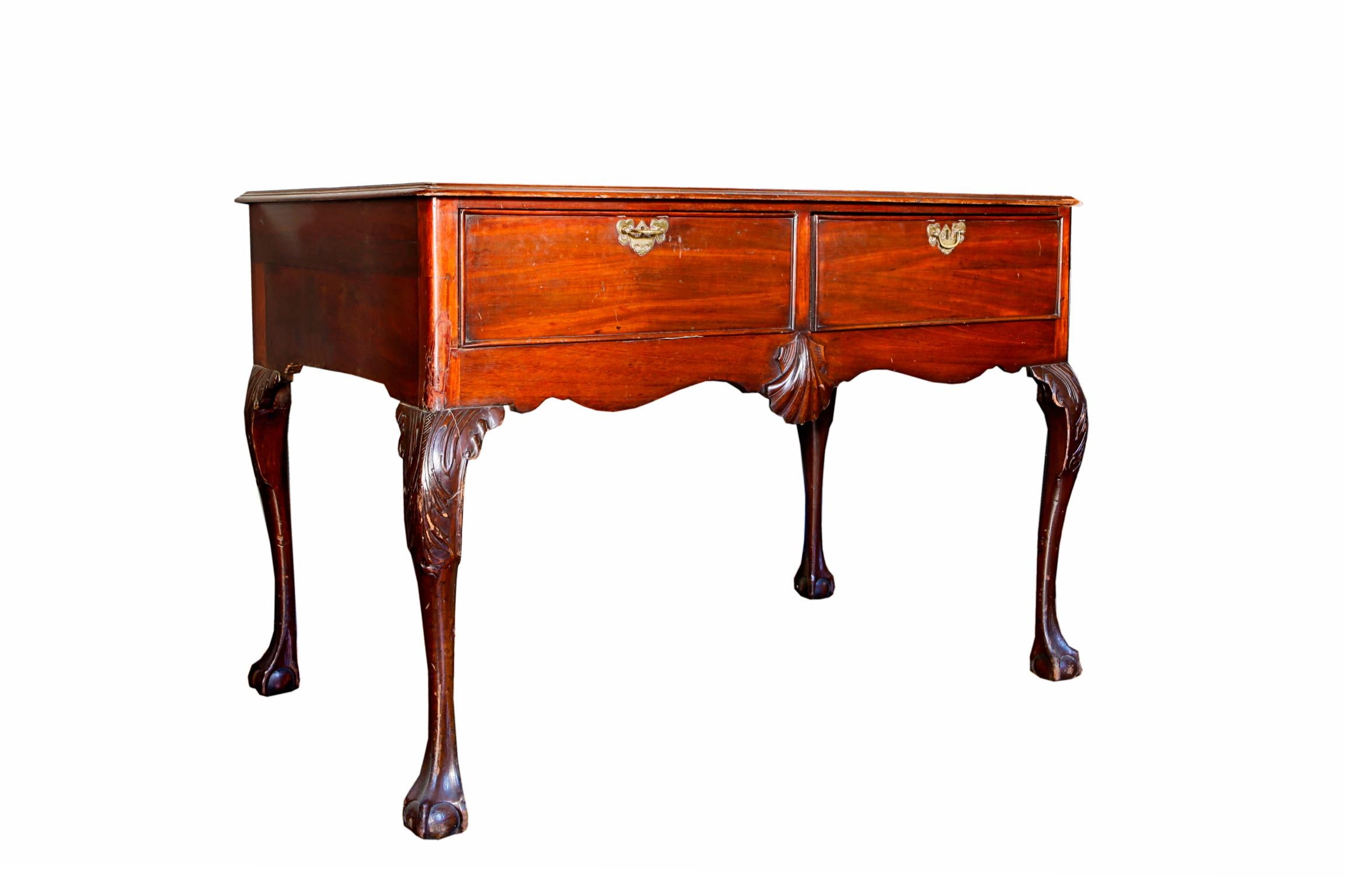 A 19th century Irish mahogany writing table or buffet. With an inset leather lined top, above two drawers, cabriole legs and finished on claw and ball feet.