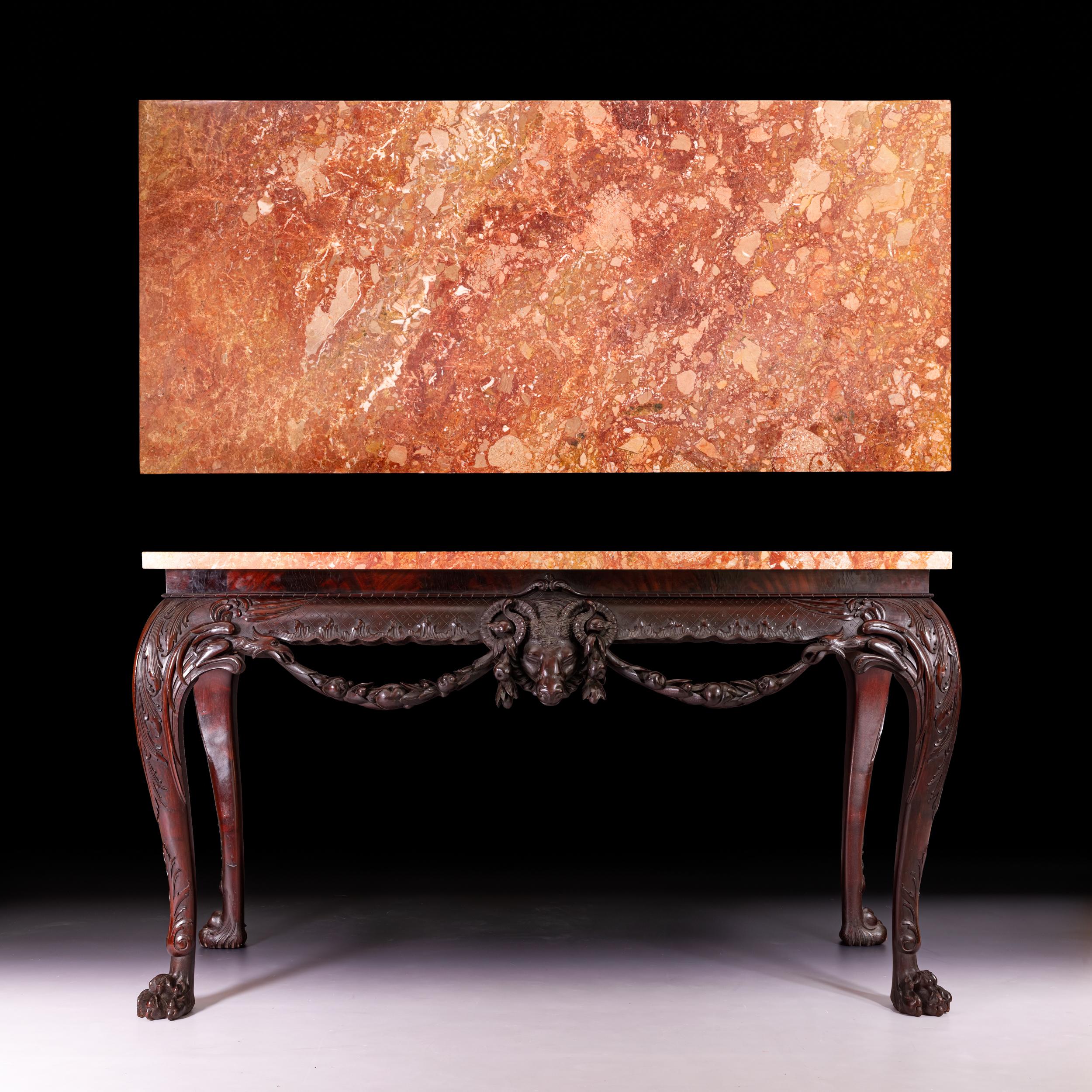A superb 19th century George III style console / side table. The rounded rectangular marble top above a shaped punched apron centred by a ram`s mask and flanking swags, foliate scroll work and flowerheads and similar sides, the cabriole acanthus