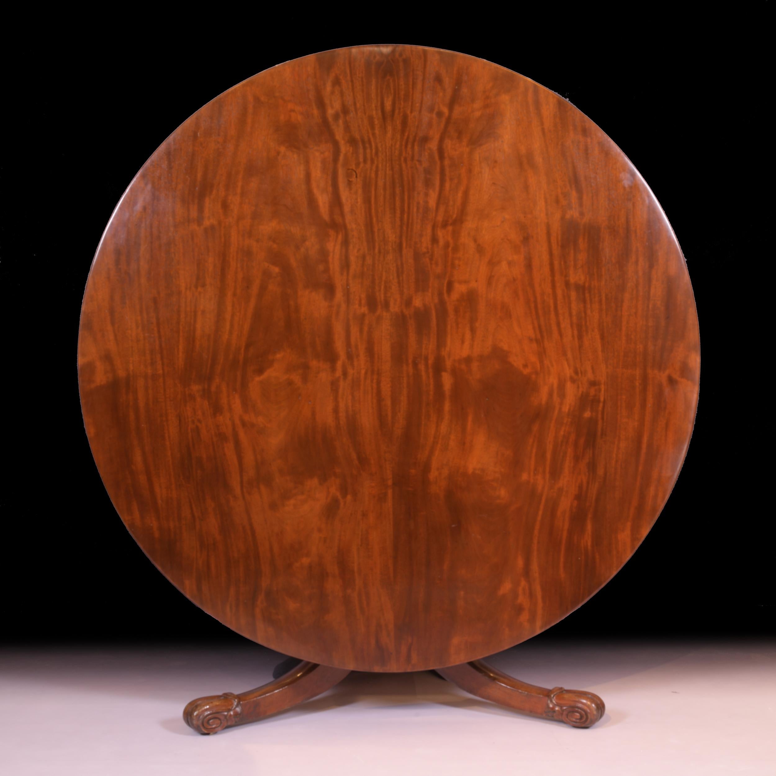 A superb Irish Regency mahogany centre / dining table by Robert Strahan of Dublin, of circular form, the solid panel top , with reeded edge, turned centre column, on lotus carved downswept legs resting on castors, stampe and numbered,