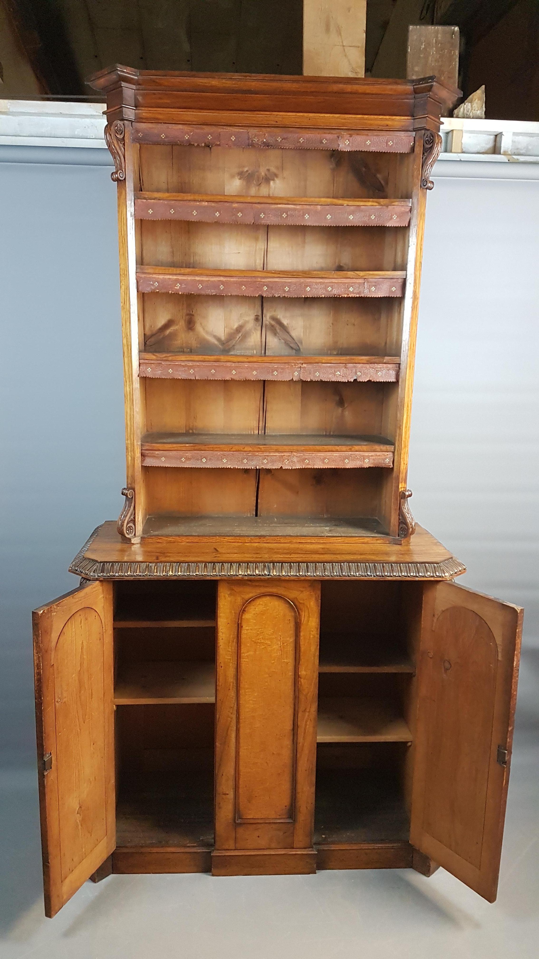 A stunning mid-19th century Irish library cupboard bookcase with subtle breakfront base. This cupboard has utilised a variety of timbers all veneered on pine, the timbers are oak, walnut, figured walnut and bird's-eye maple. The top and base have