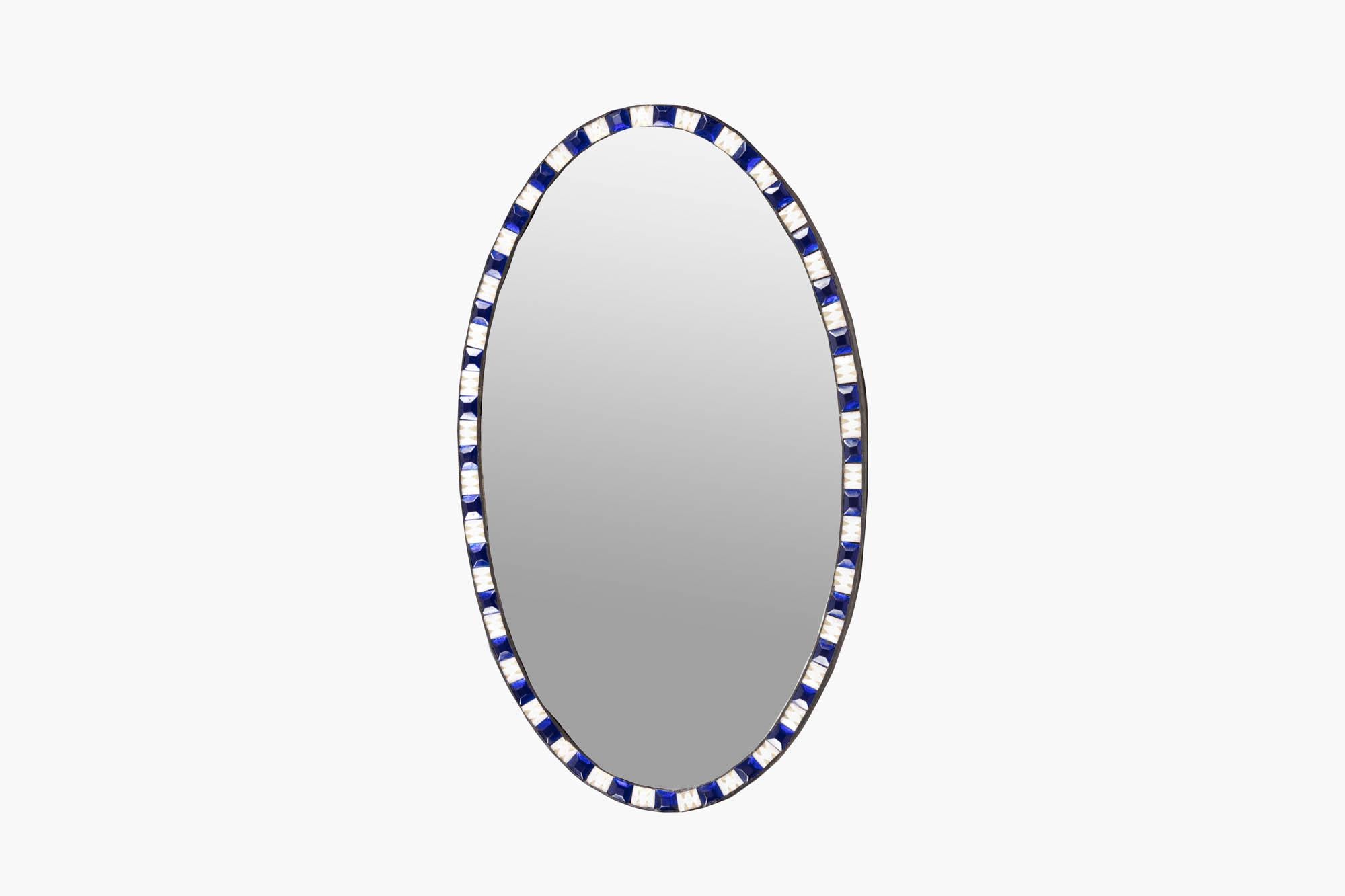 19th Century Irish Waterford mirror complete with period plate of oval form, and decorative beveling to the outer edge. It is set within frame of alternating faceted blue and clear glass studs.

Circa 1840.
