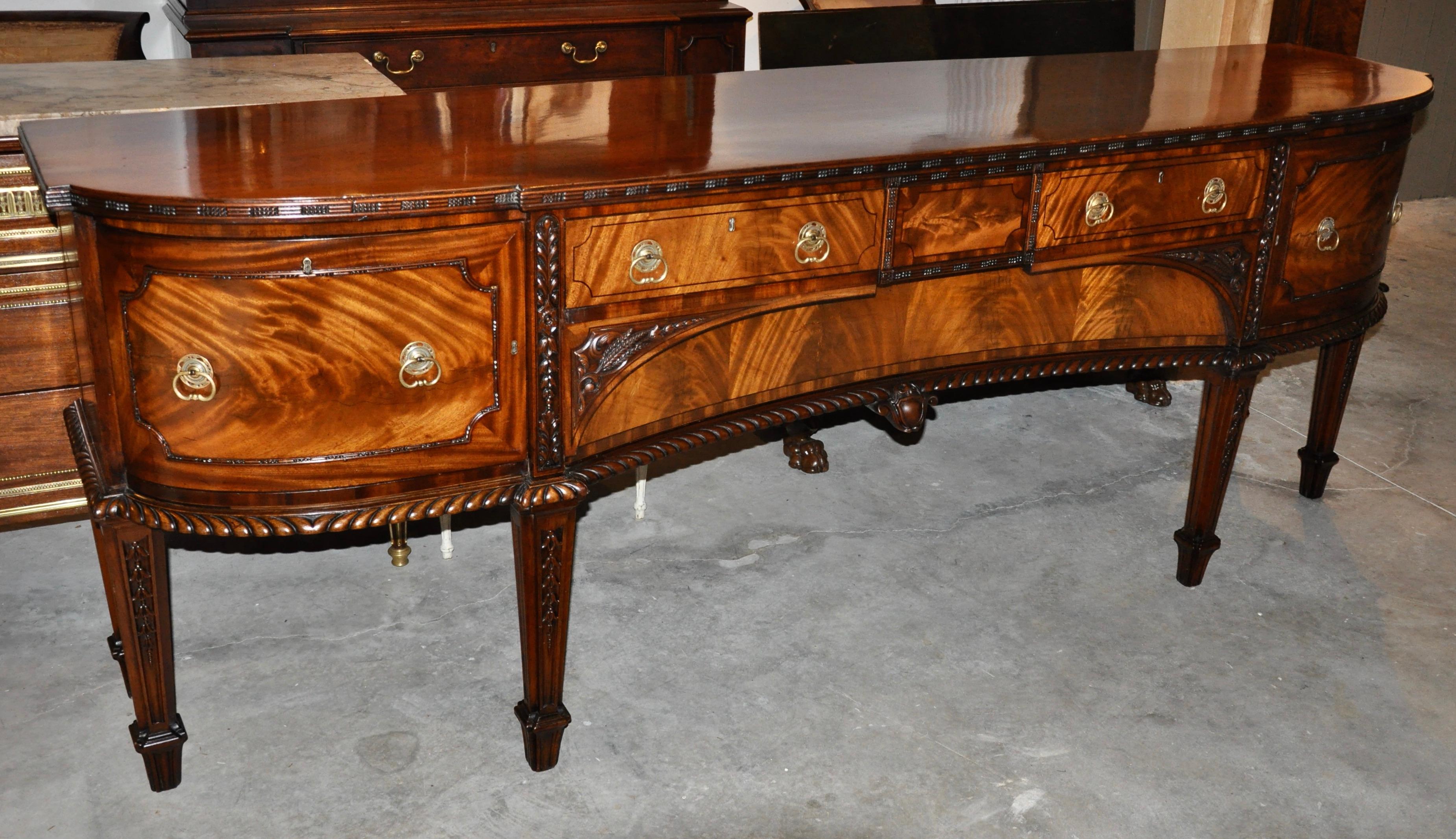 Early 19th century Irish mahogany sideboard. Well figured wood with carvings of wheat and bellflowers. With right wine drawer and early pulls. Great length yet shallow depth.
