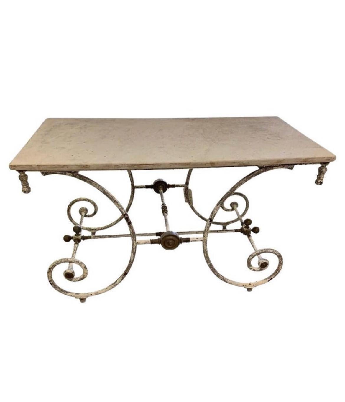Preciosa mesa pastelera francesa del siglo XIX con tapa de mármol y pátina de pintura blanca antigua en la base de hierro. Esta belleza presenta herrajes decorativos de latón patinado y una encimera de mármol blanco veteado. Ideal para usarla como