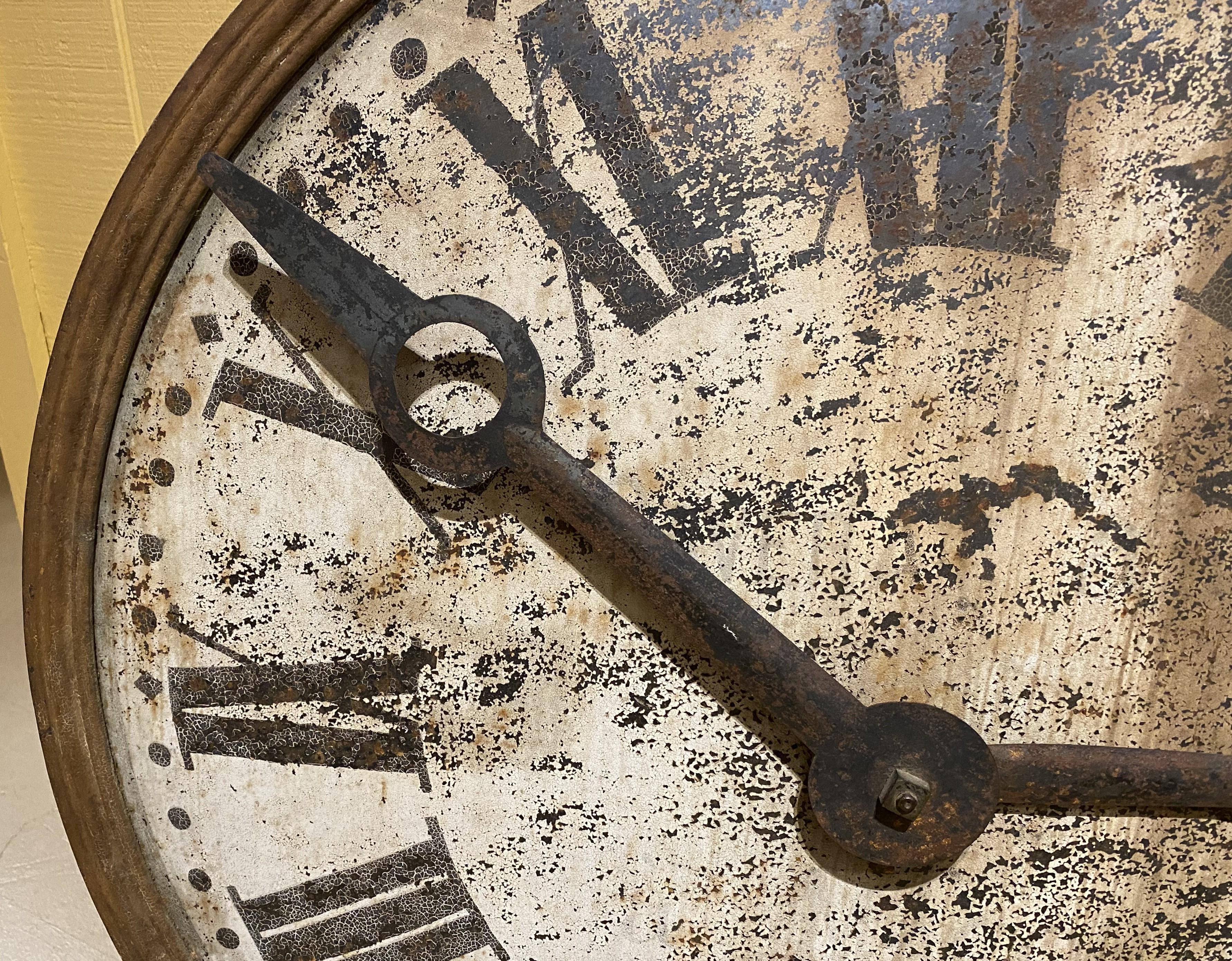 A wonderful example of an iron clock dial with hands, painted Roman numerals, and motion works, as well as the original counterweight. Probably American in origin, from a tower or building pediment, dating to the 19th century, in good overall