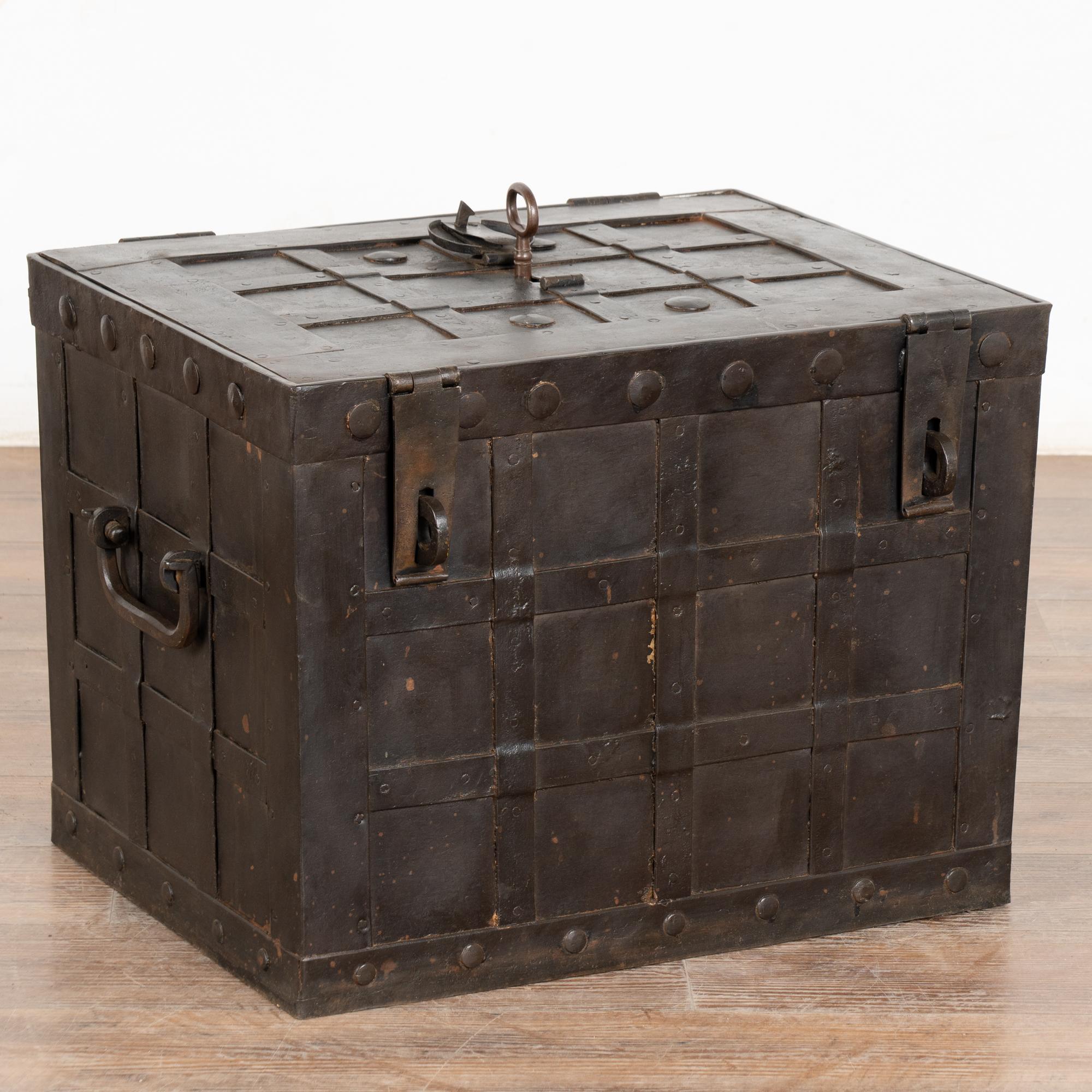 This iron lock box is loaded with character from the  heavy iron side handles, rivets and iron straps throughout.
There are two hinged latches allowing for additional padlocks to be added. Key is included with covered lock on center top.
While