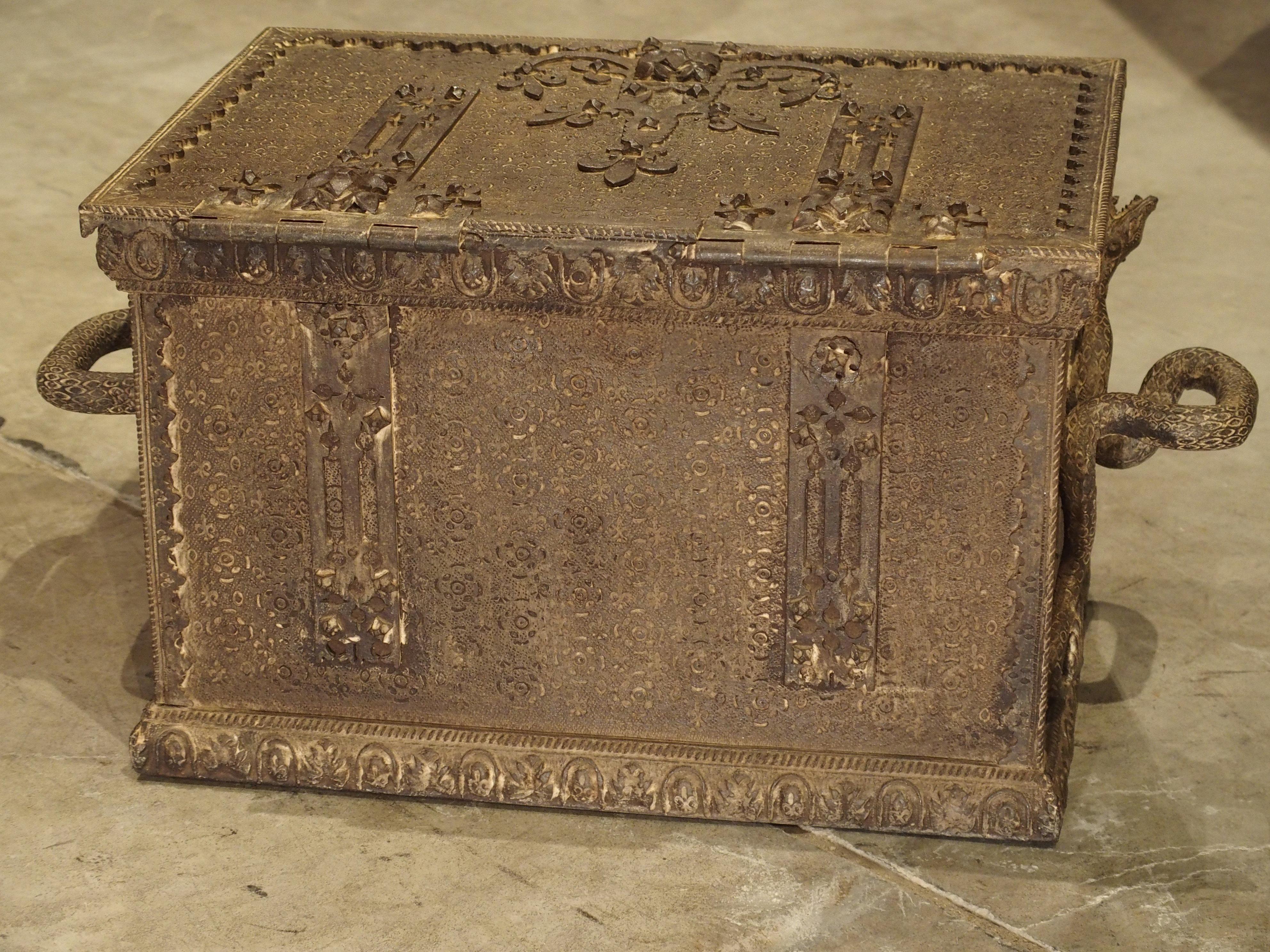 From France, this highly detailed and unusual iron and velvet lined strongbox has been stamped with multiple types of fleur de lys, oval motifs, stylized lily motifs and other various geometric shapes. The forged iron hinge straps and latch plates