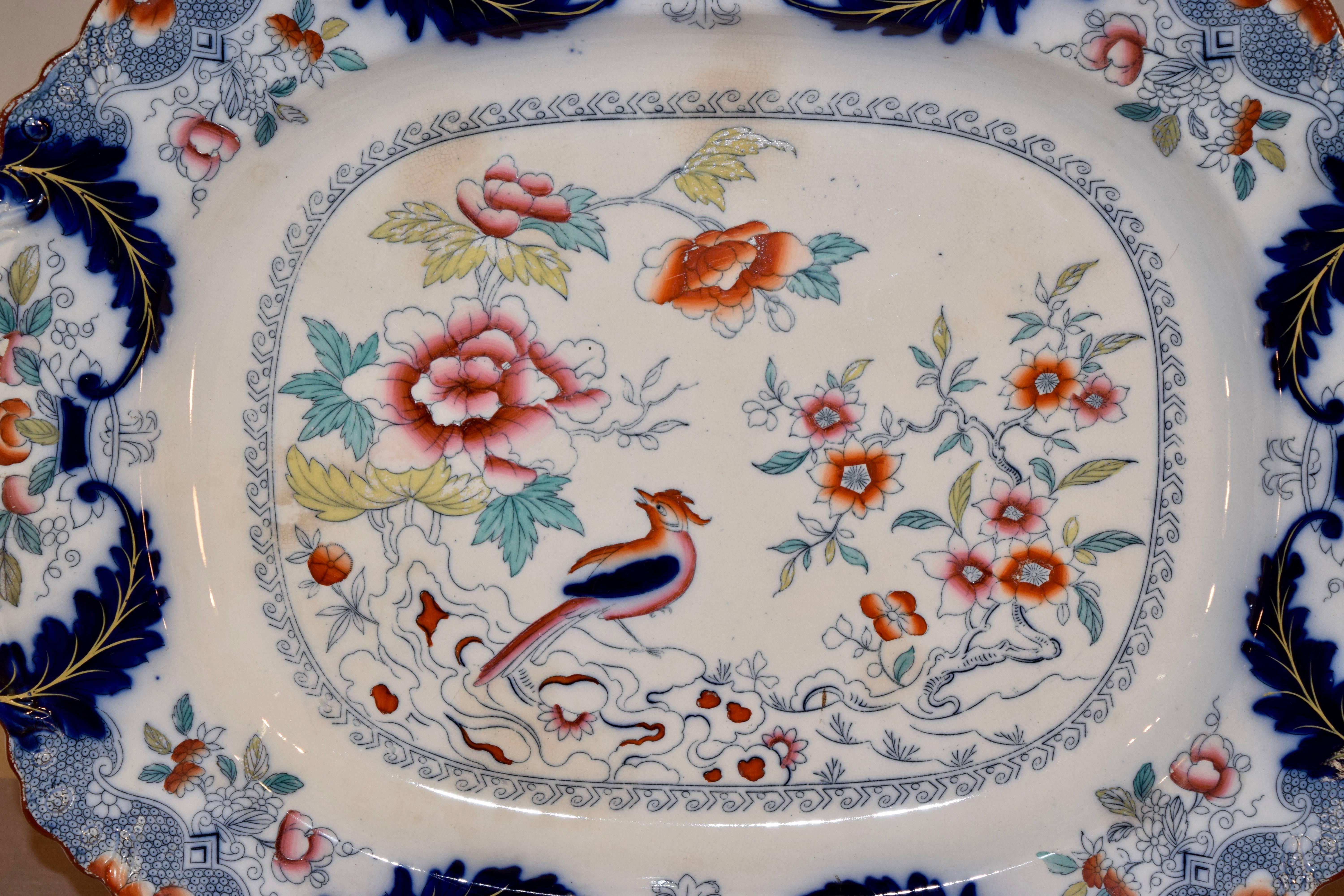 Very large 19th century English ironstone platter with transfer of birds and flowers, which has then been hand polychromed for lovely accents. The edge of the platter is scalloped as well. There is a date lozenge on the back which is indecipherable.