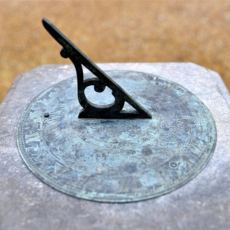 This sundial is made of stone from Istria Country, Croatia. This type of stone has been carved since the Roman ages. It has ornate hand carving on its base and the dial itself is made of bronze. The gnomon features a beautiful scroll shaped design
