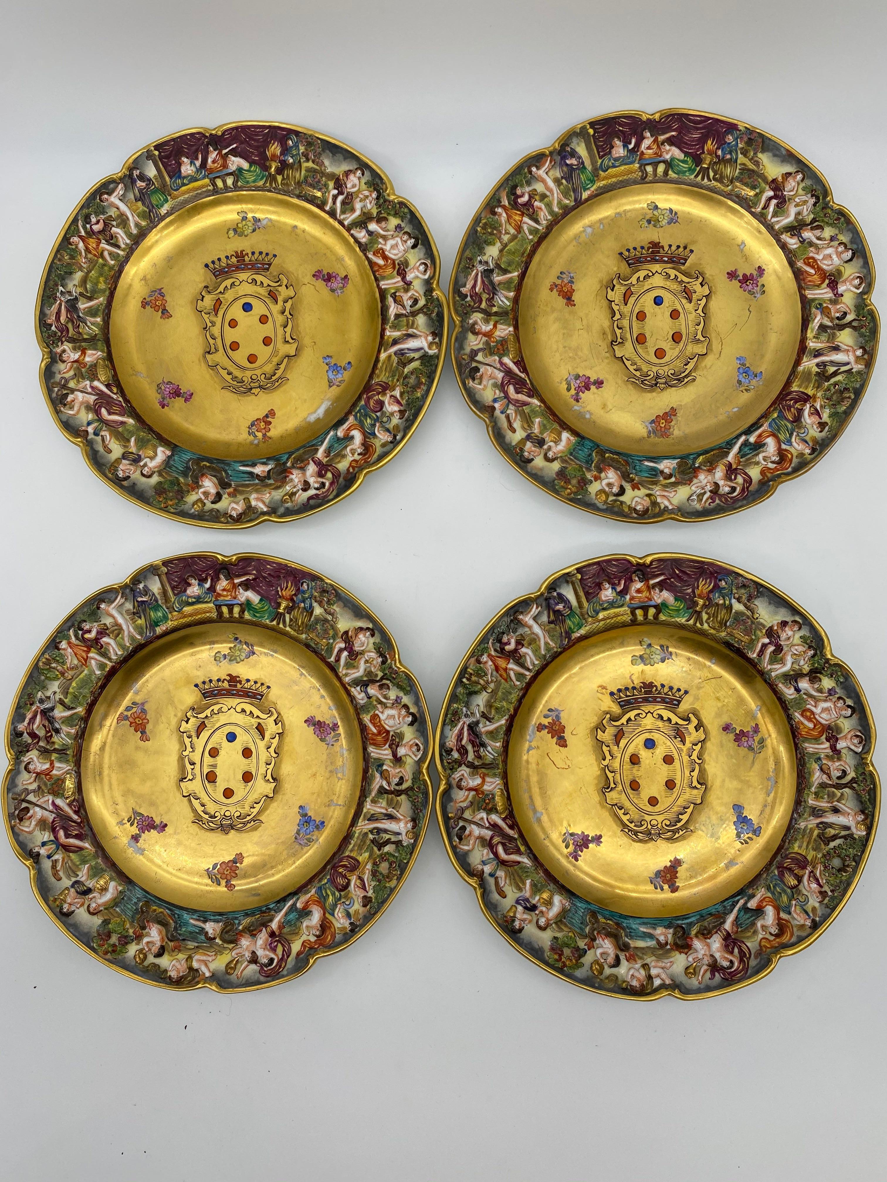 Set of 4 of 19th century Italian Capodimonte gilded porcelain relief-edge plates, each painted with the Medici family coat of arms, rims with relief molded decoration of nymphs and putti, bases stamped with blue five-point coronet and N mark within