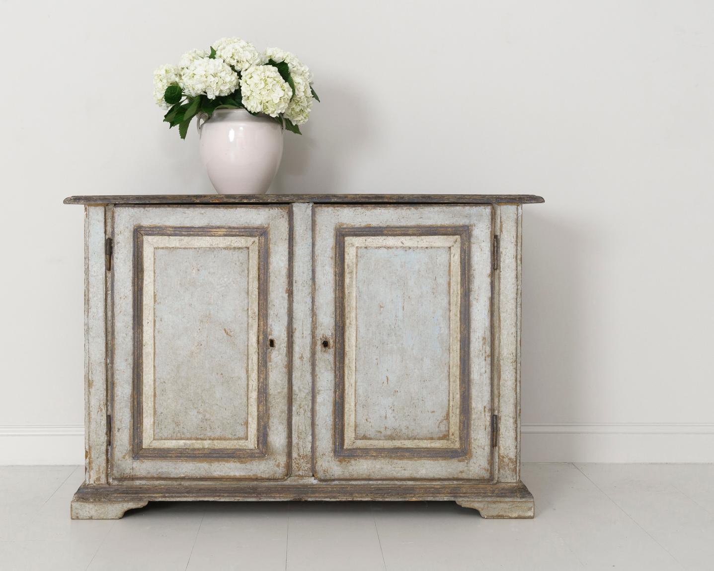 An incredible early 19th century Italian buffet sideboard, circa 1820, in original paint found in Abruzzo, Italy. The doors open to reveal two drawers with original insets and three fixed shelves. The overall patina is a beautiful soft blue - gray