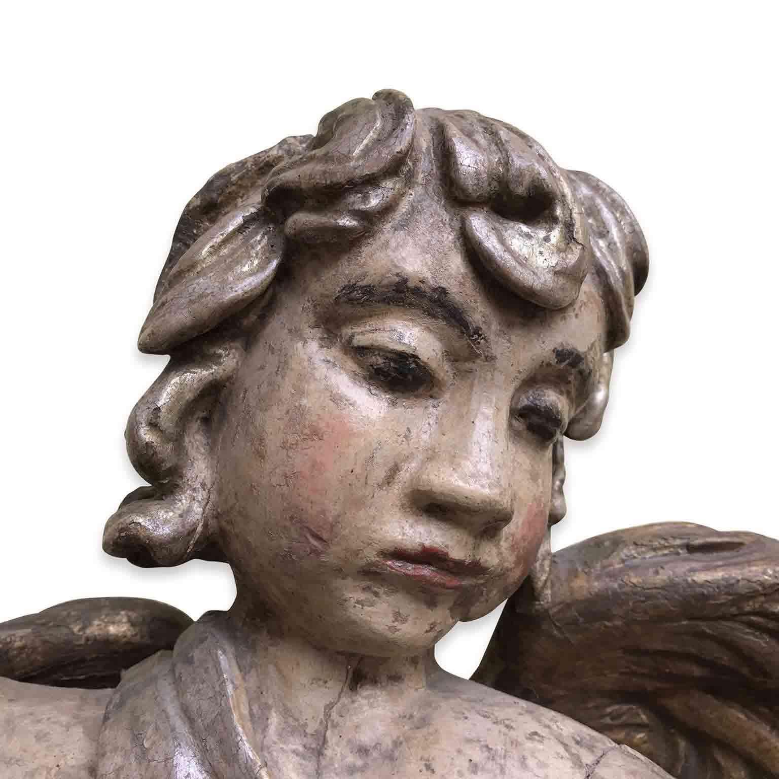 Lovely Baroque style Announcing Angel, an Italian figurative sculpture carved in cembran pinewood painted, silvered and giltwood of Italian origin, dating back to 9th century, in overall good condition.
This antique wall-hanging figure is a hand