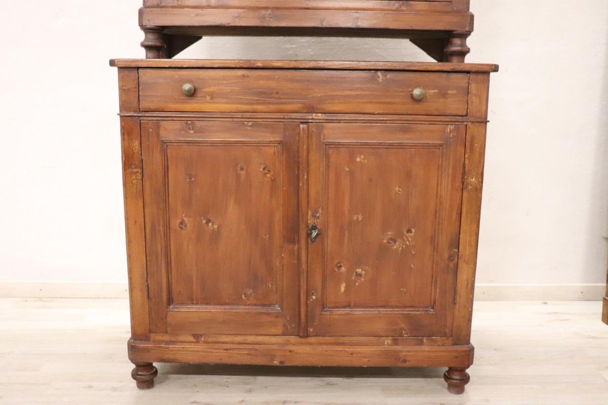 Nous vous présentons ce buffet rustique italien ancien, fabriqué au milieu du XIXe siècle en bois de sapin massif. Ce buffet haut est composé de deux parties distinctes qui permettent également de le déplacer facilement.

La partie supérieure se