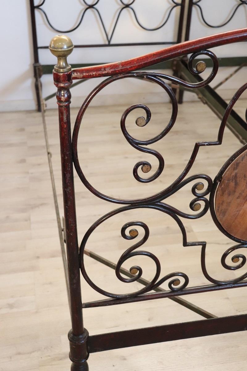 Beautiful antique wrought iron pair of single beds from the 19th century, very spectacular. An elaborate wrought iron decoration with many curls and swirls. The iron is completely hand-worked. Embellished with golden hand painting that gives
